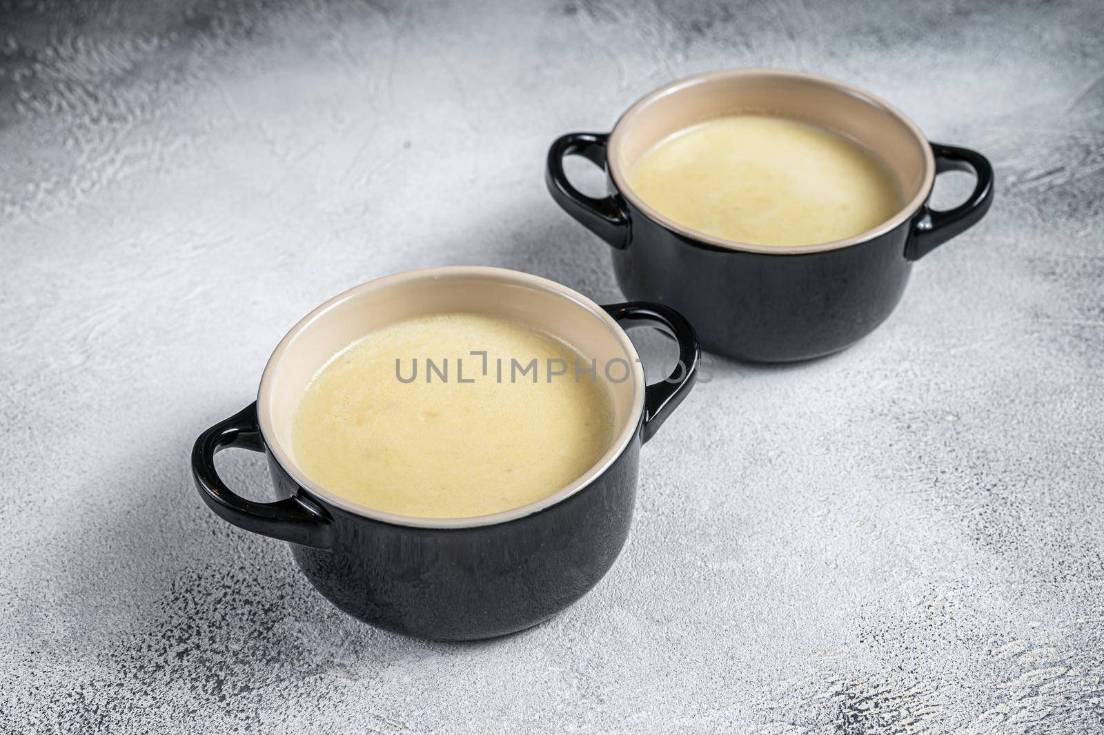 Homemade potato cream soup in bowls. White background. Top view by Composter