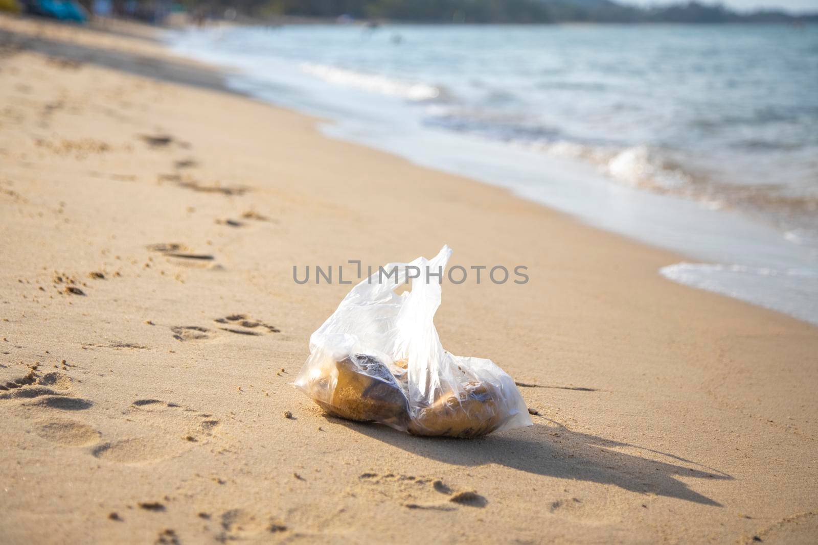 plastic bag lying on a sandy tropical beach. environmental pollution. trash in the sea