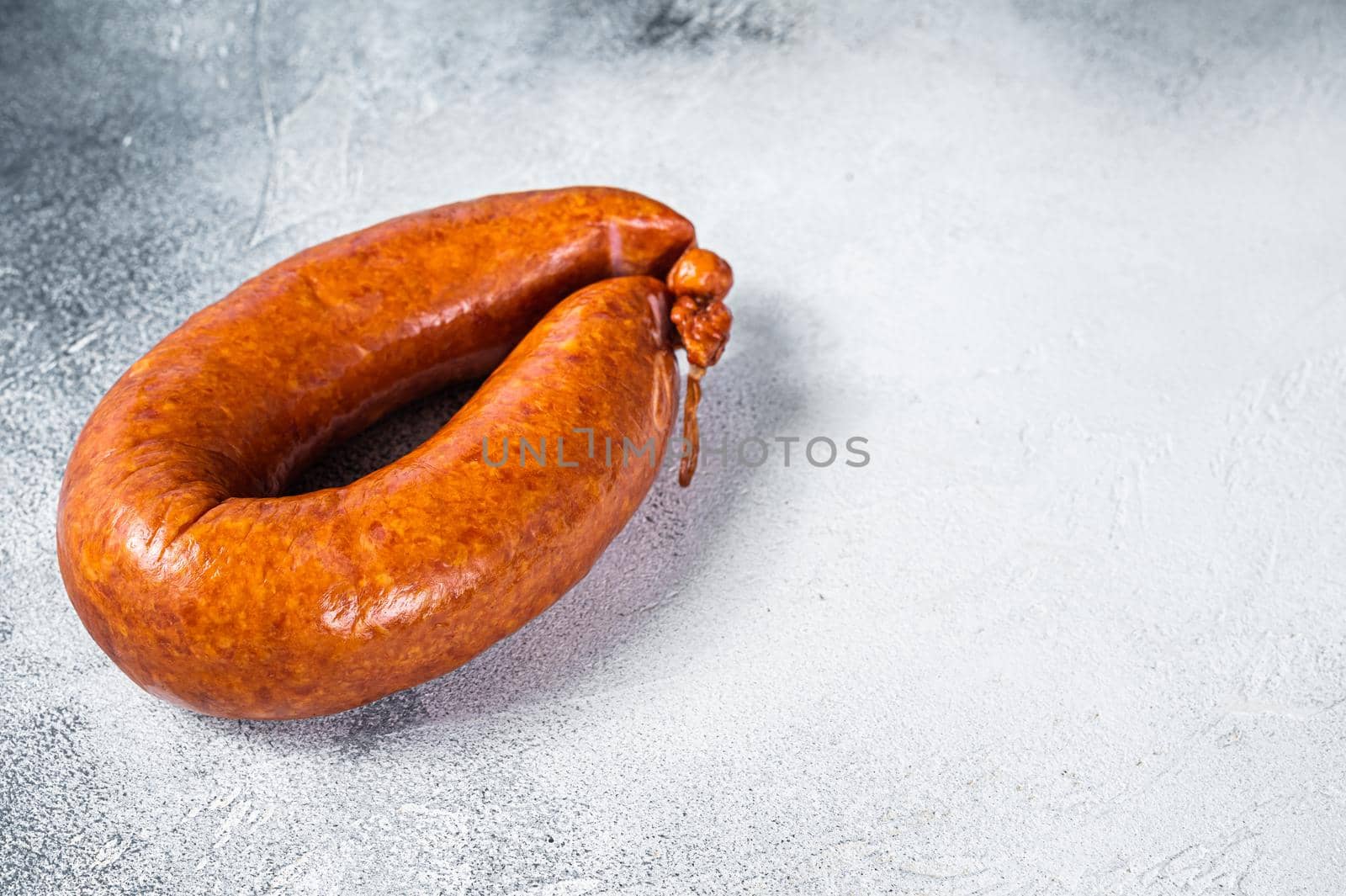 Smoked sausage on a white rustic table. White background. Top view. Copy space.