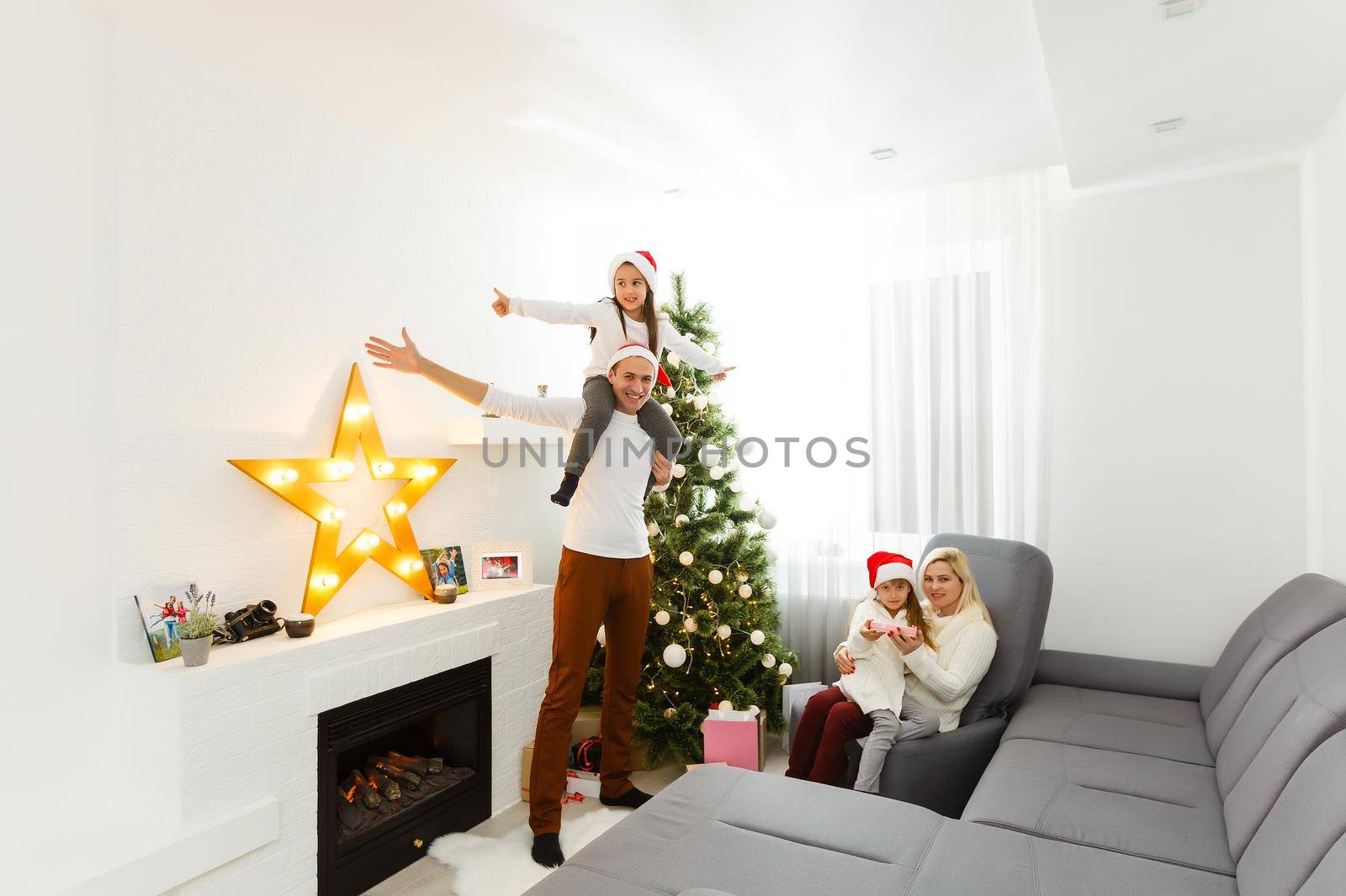 Happy family playing with Christmas gifts at home