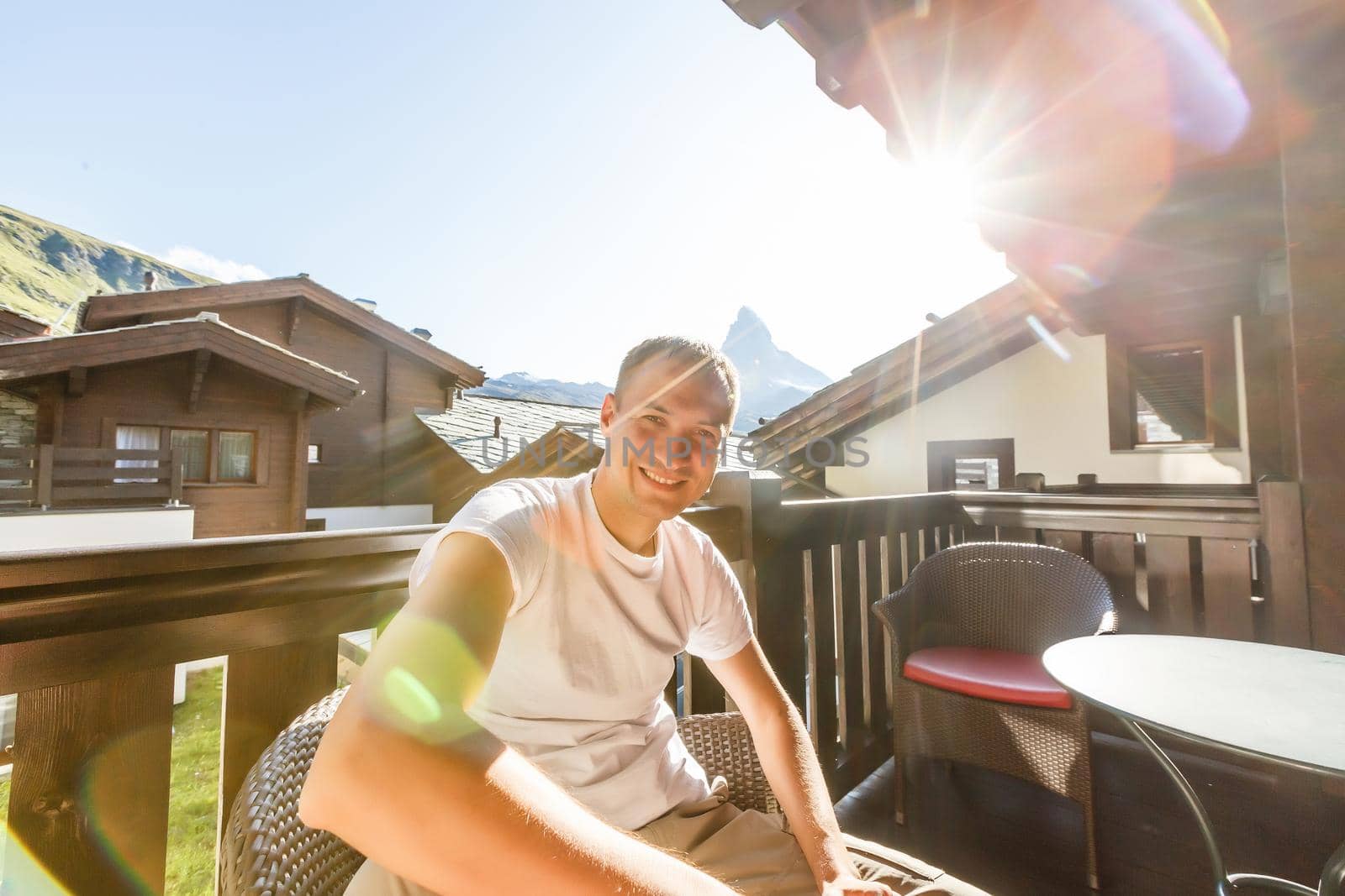 A young man in the morning looks from the hotel balcony with a view of the mountains. Mountain views at the hotel resort