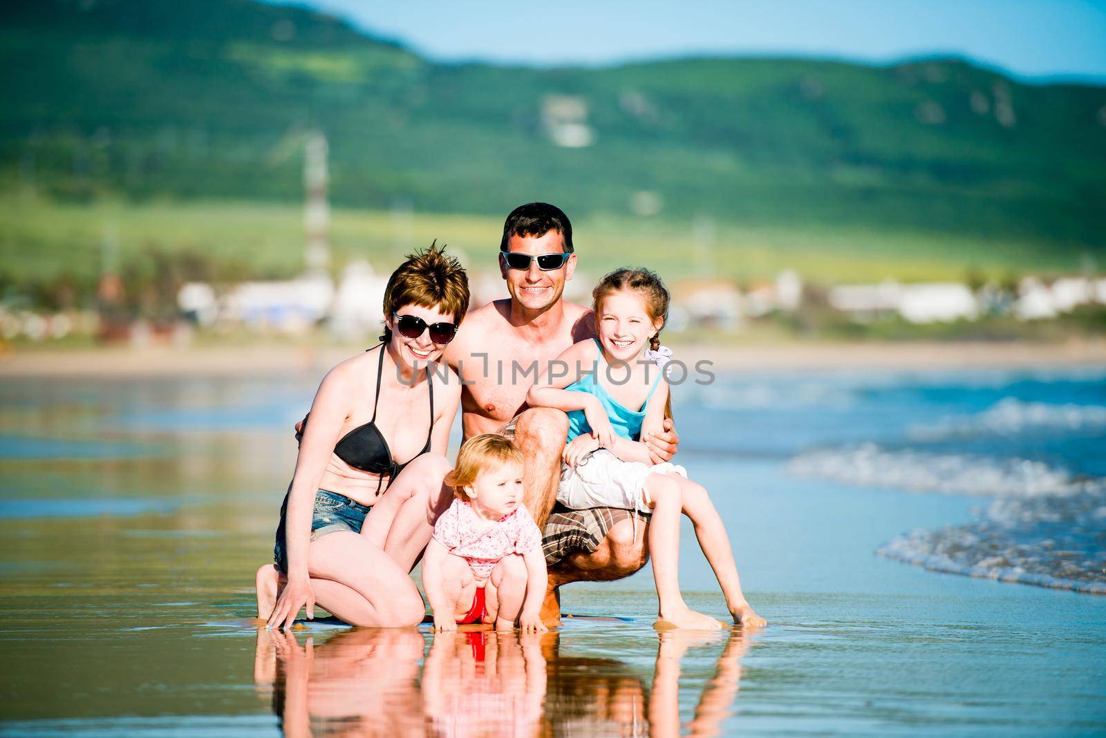 Family with two daughters having fun at the beach