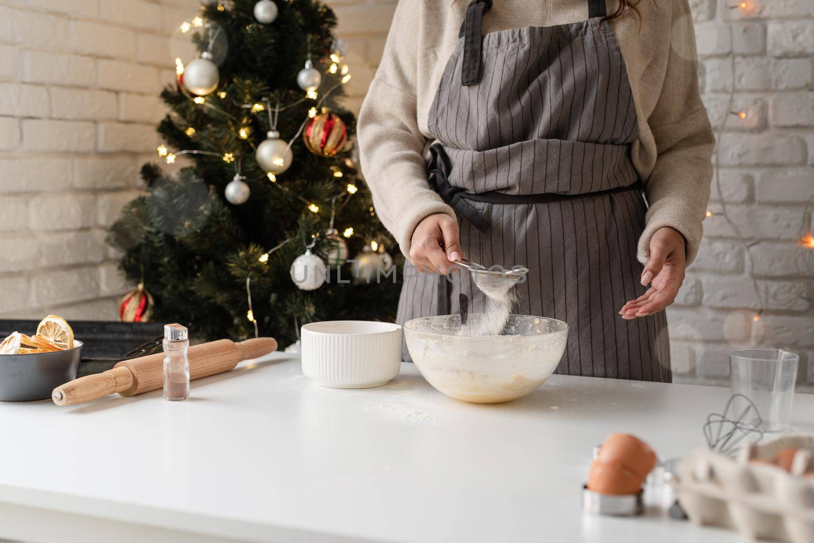 Smiling woman in the kitchen baking christmas cookies by Desperada