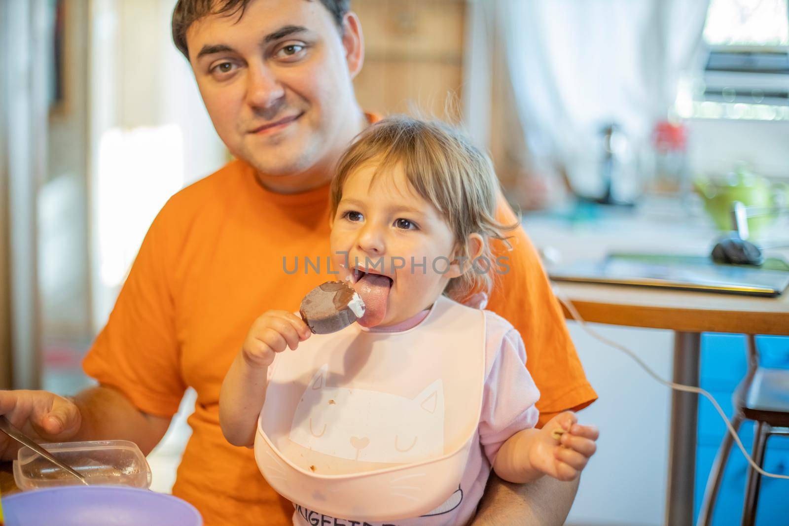 funny child eating ice cream. father feeding baby lanch. happy family meal