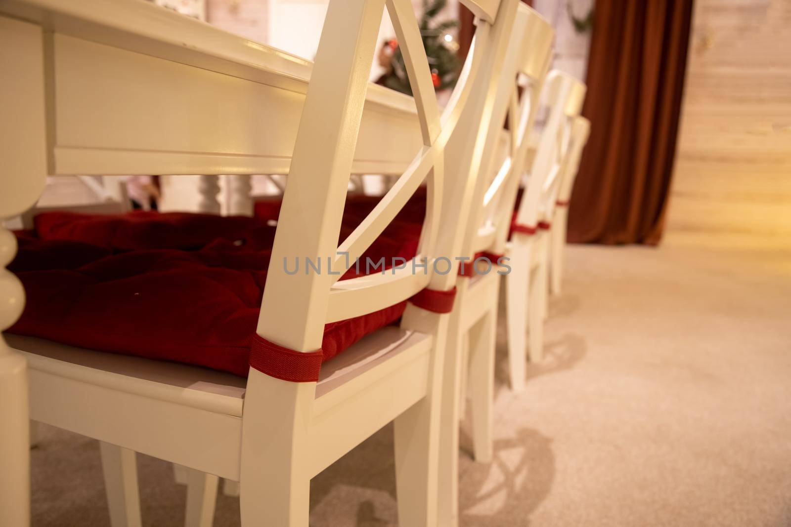close-up of white dining table with red pillow on background of festive new year celebration interior