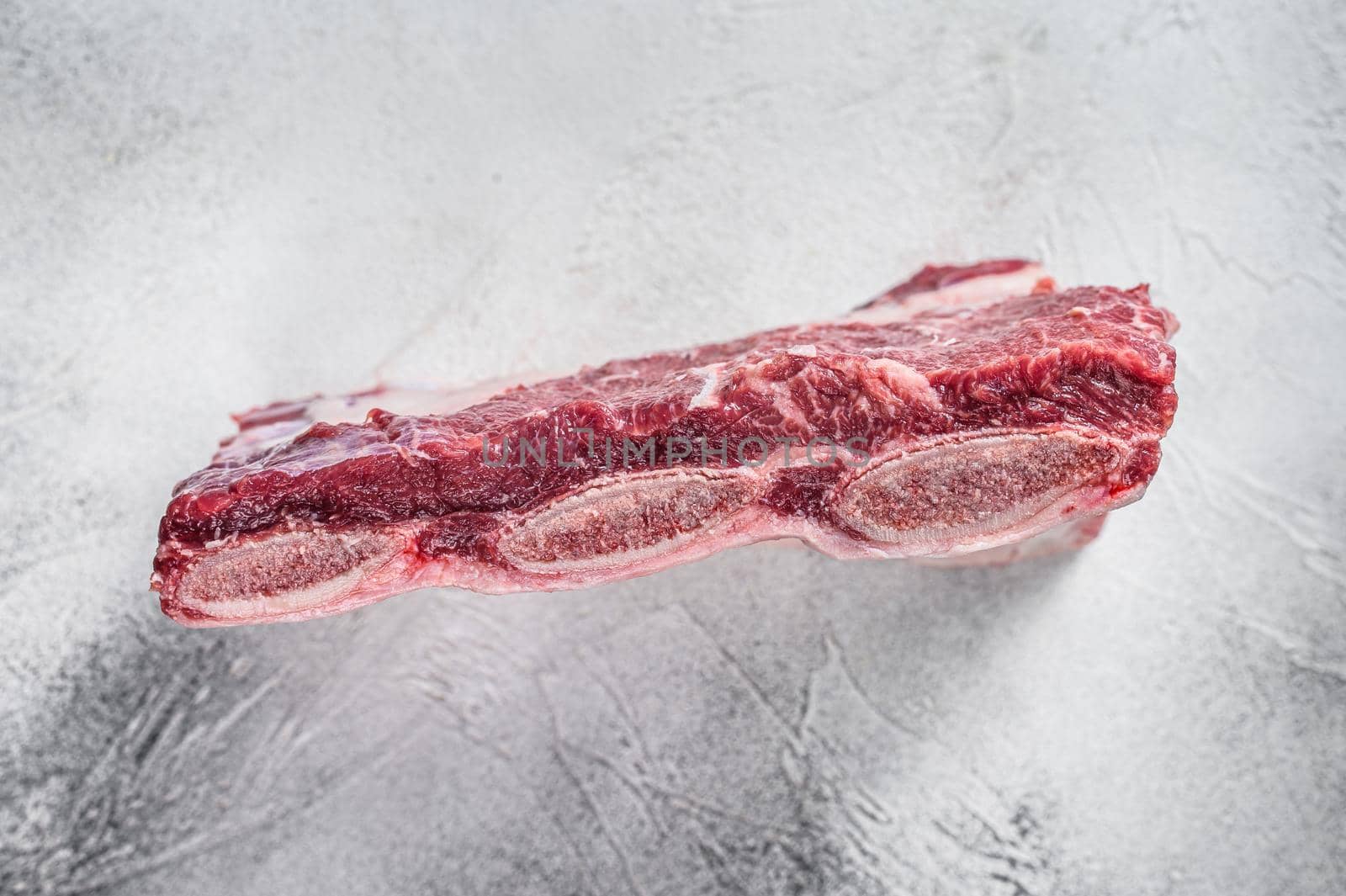 Raw beef short ribs kalbi on kitchen table. White background. Top view by Composter