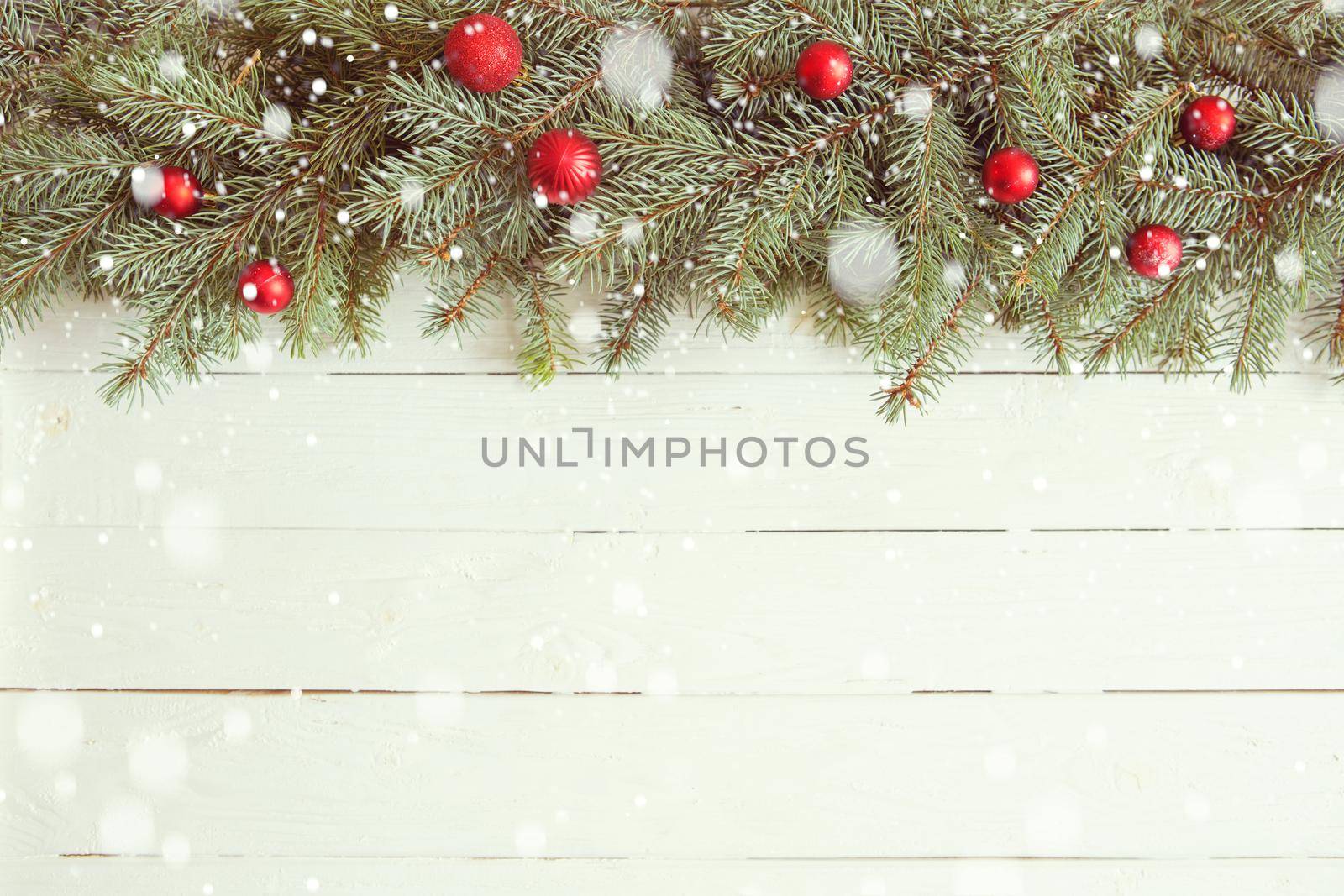 Red Christmas decoration on white wooden background.