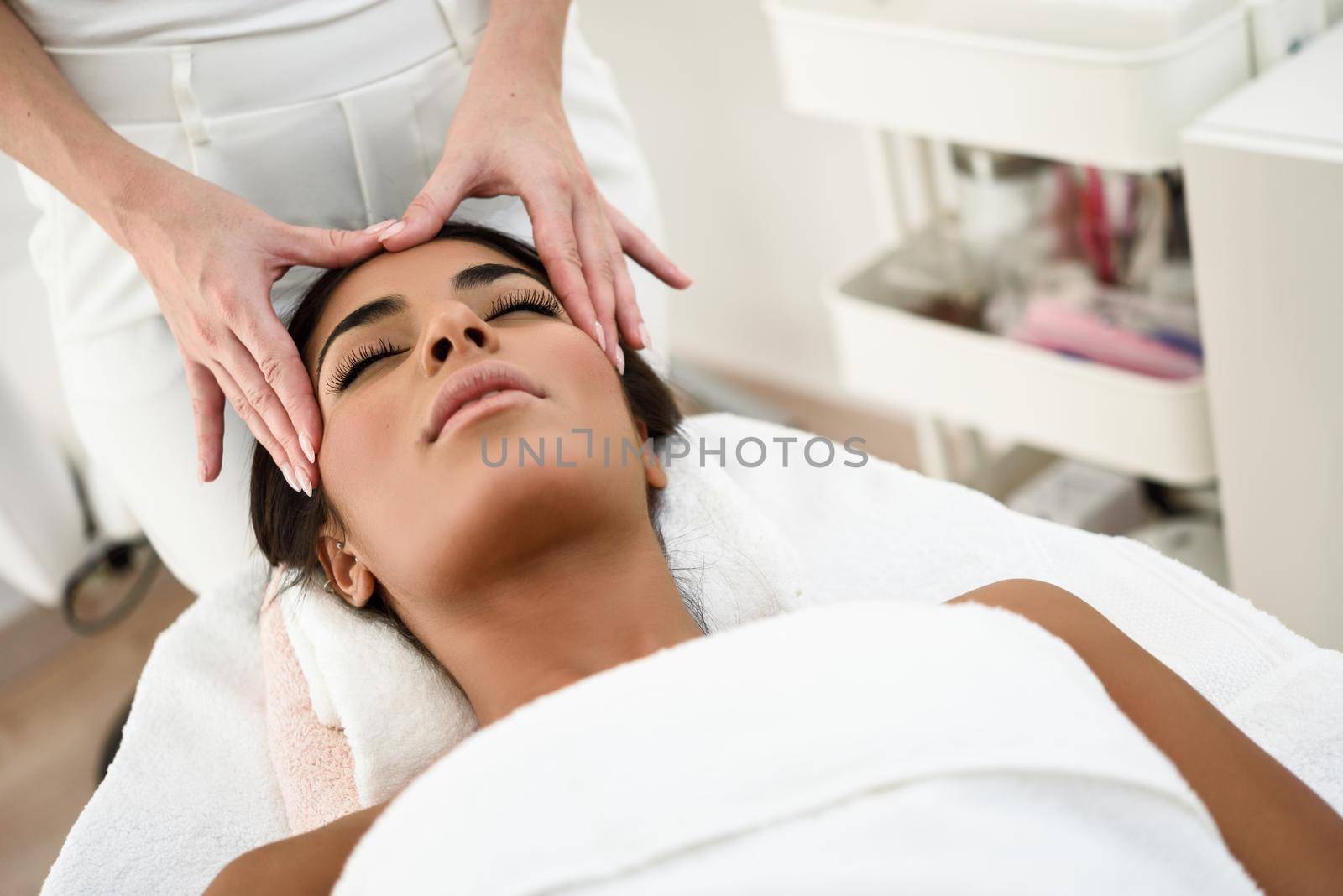 Arab woman receiving head massage in spa wellness center. Beauty and Aesthetic concepts.