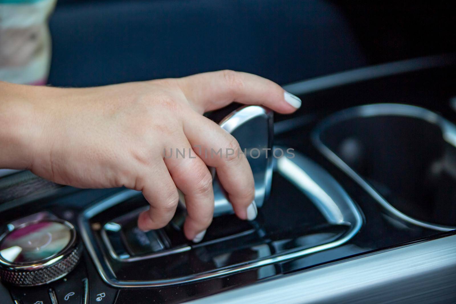 hand switches modes on the automatic transmission lever. close-up. no face. Driver woman hand holding automatic transmission or variable speed drive in car, shifting gear stick before driving car.