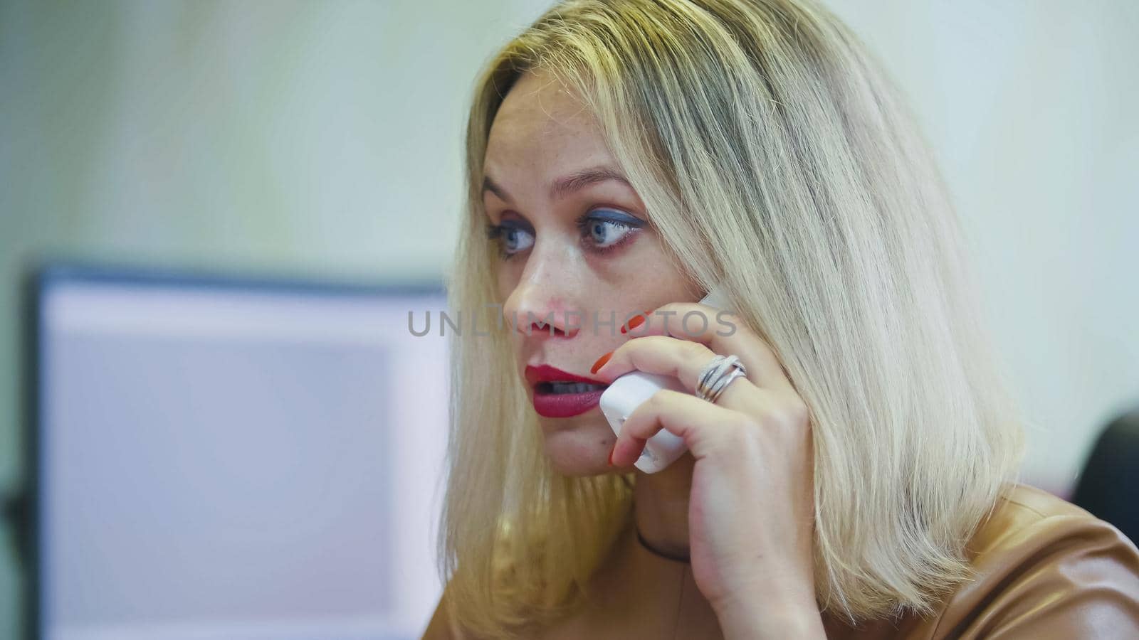Young Blonde Woman in office talking on phone - in front of the computer, handset with wire close up by Studia72