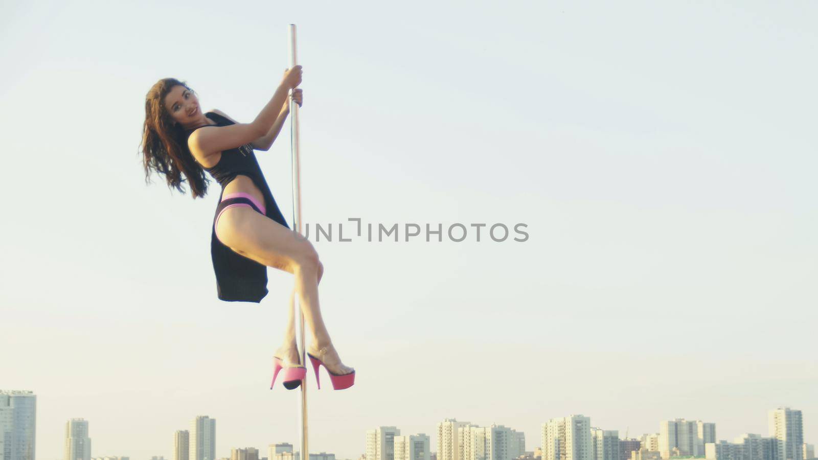 Fit attractive girl dancing near portable pole at summer day over the skyline, slow-motion by Studia72