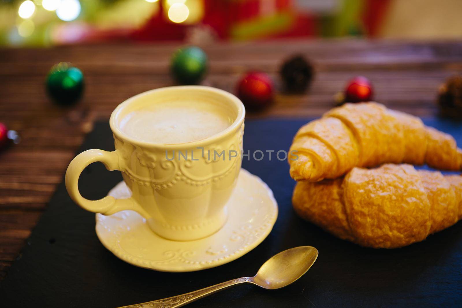 Mug with hot chocolate on a wooden table with Christmas decorations .