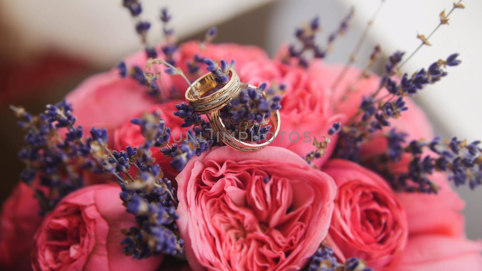 Golden wedding rings in center of bride's bouquet by Studia72