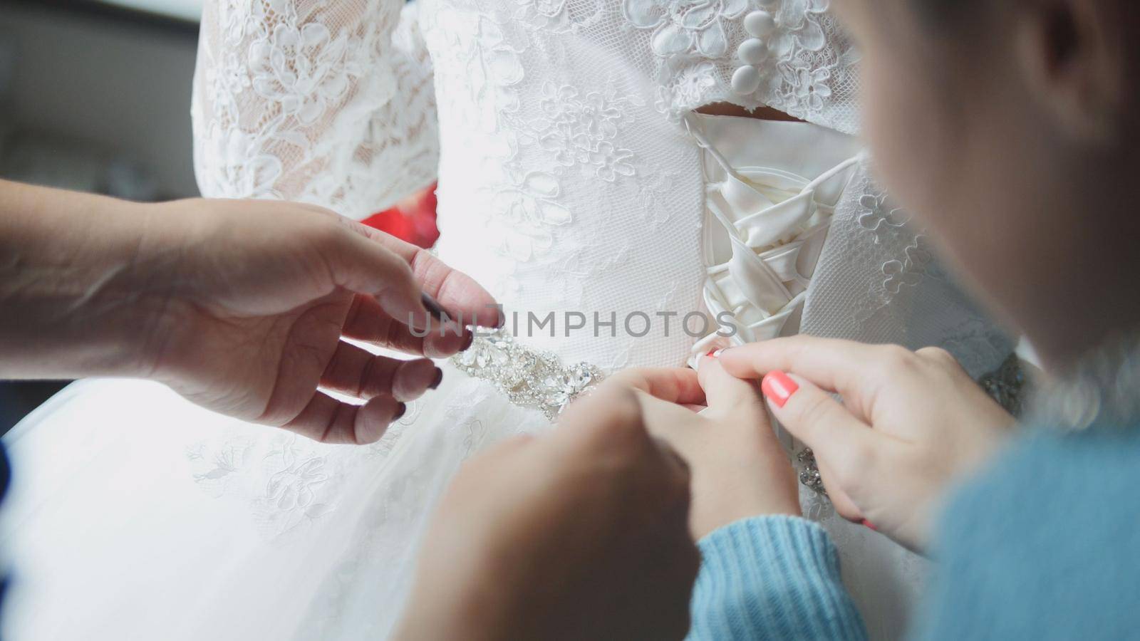 bridesmaid buttoning dress at bride's home, close up