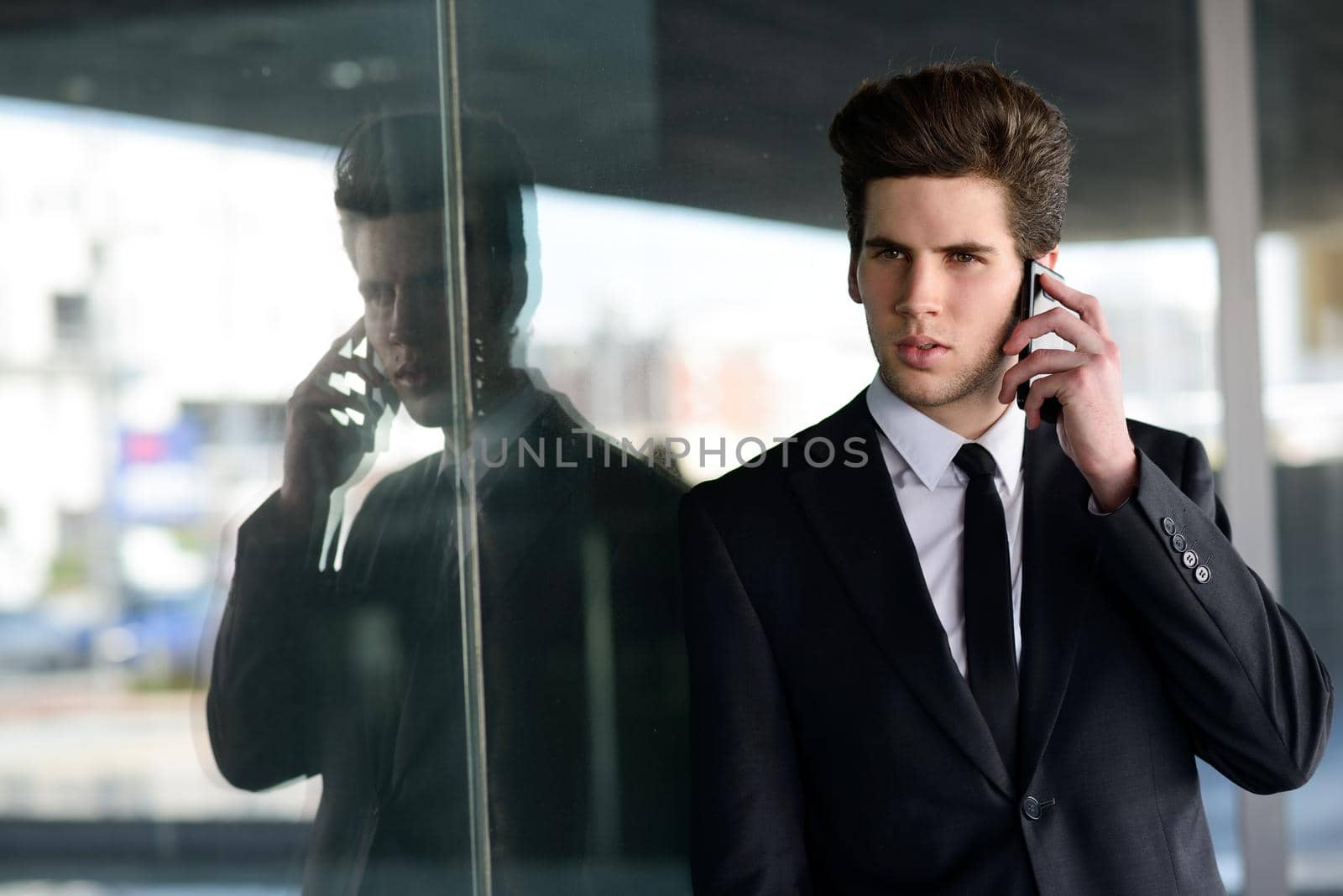 Attractive young businessman on the phone in an office building by javiindy