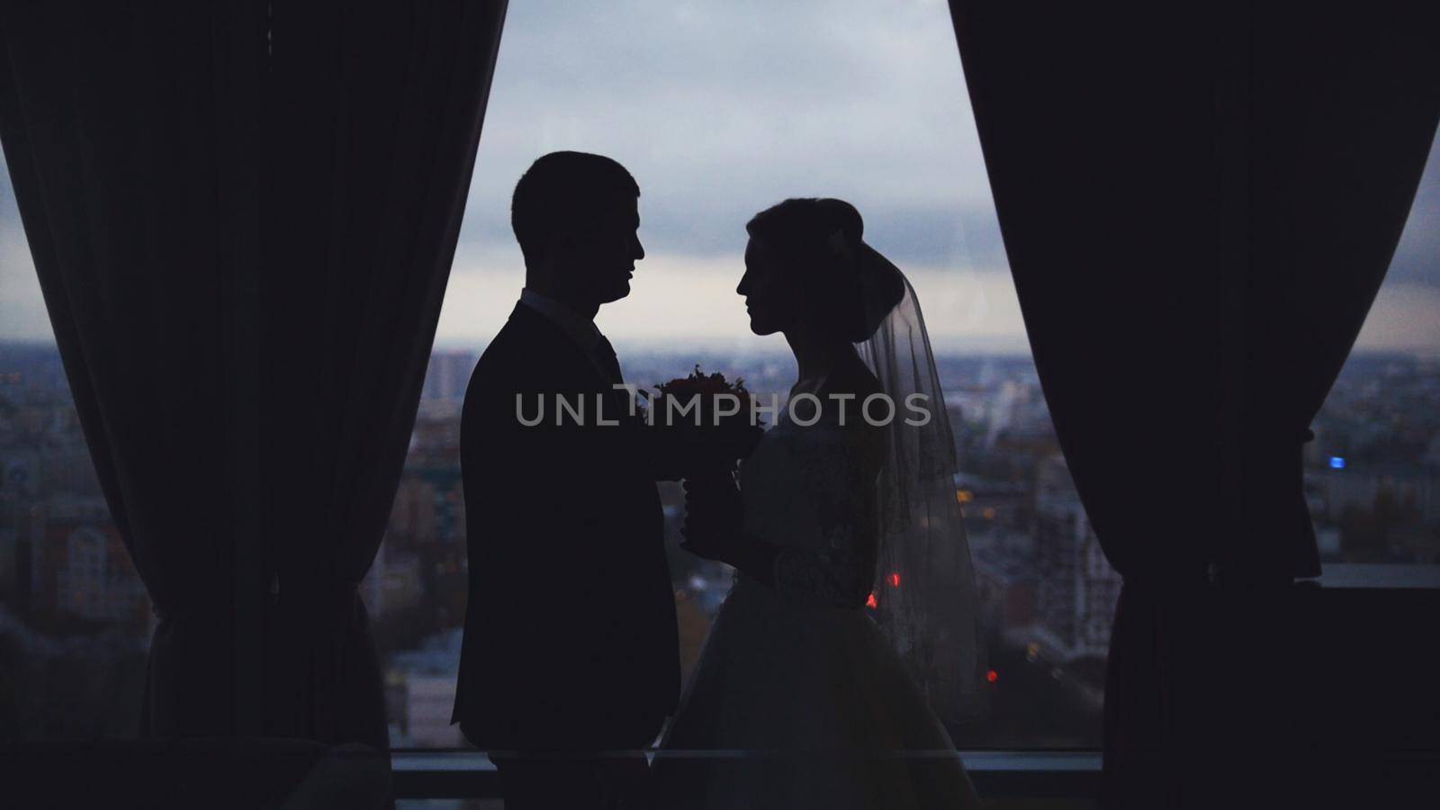 Silhouettes of the bride and groom on the background the city by Studia72