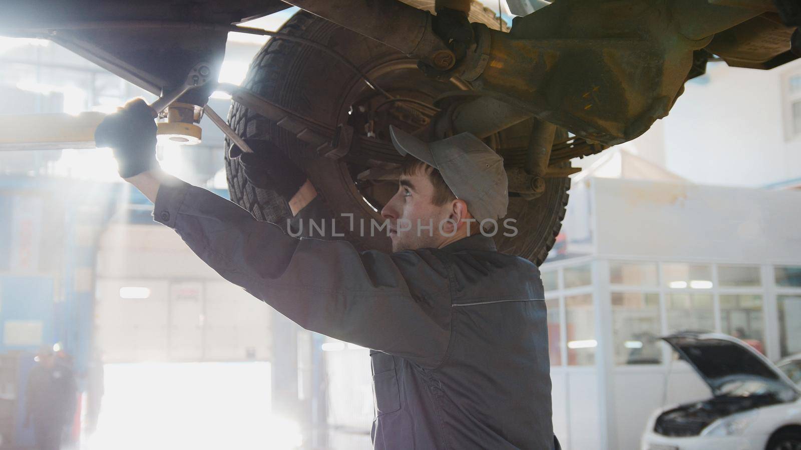 Garage automobile service - a mechanic checks the wheel, close up, horizontal