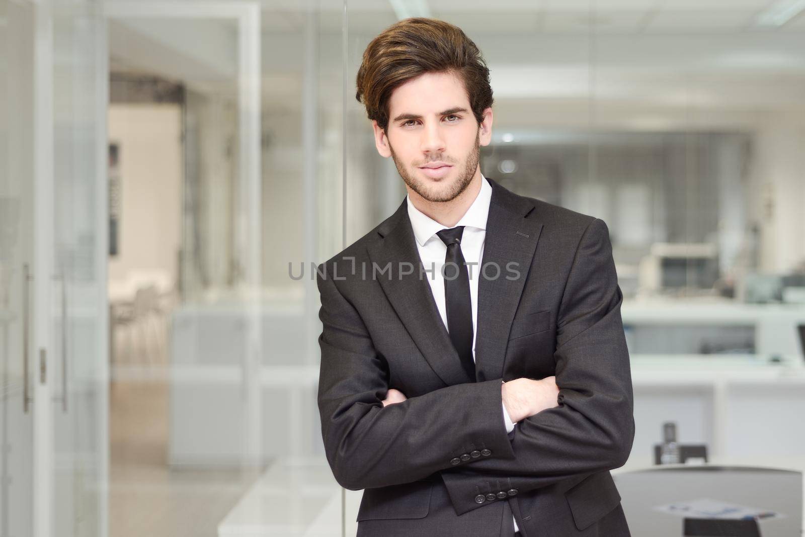 Handsome young businessman in an office by javiindy