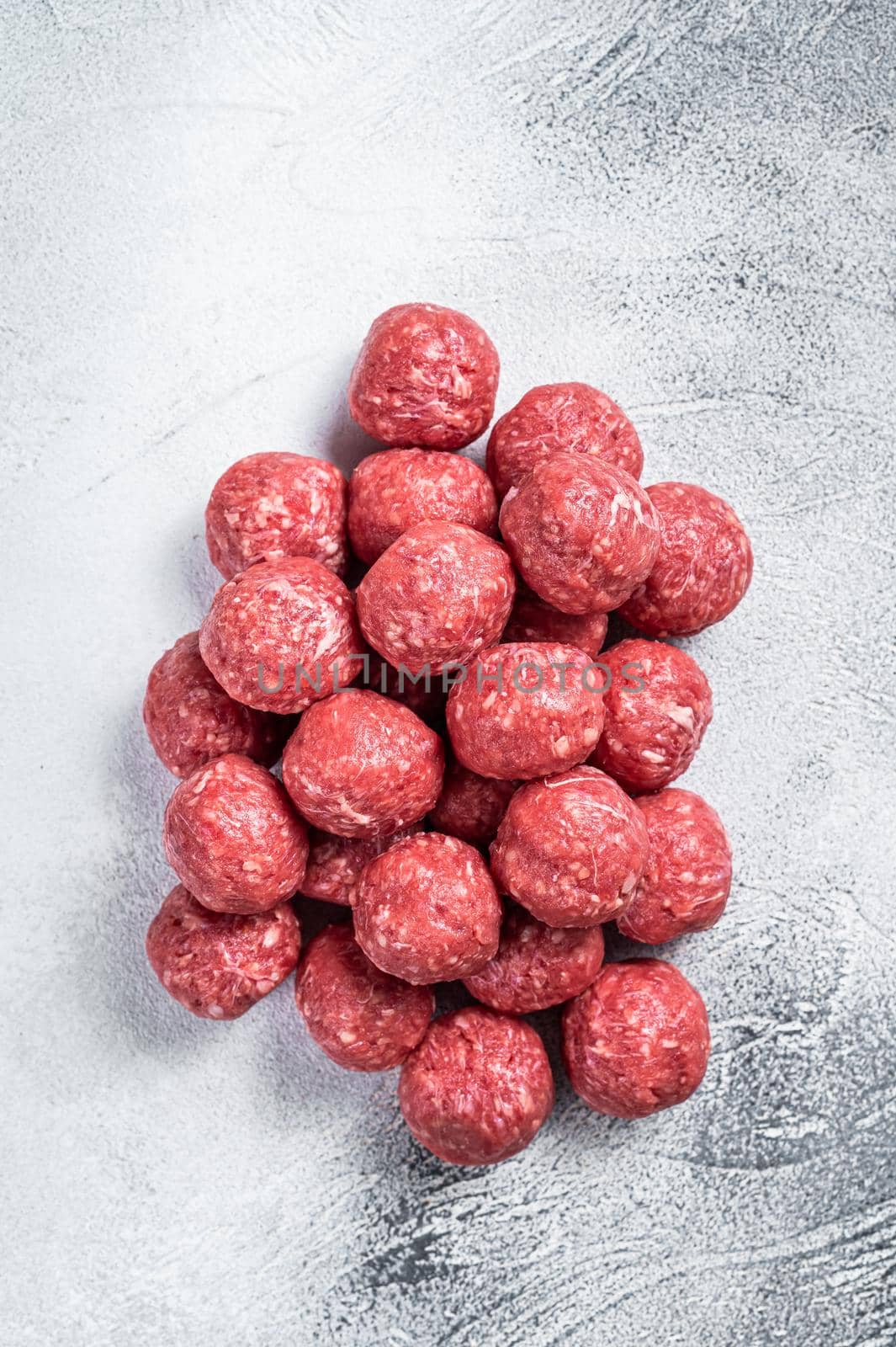 Raw beef and pork meatballs with spices on kitchen table. White background. Top view by Composter