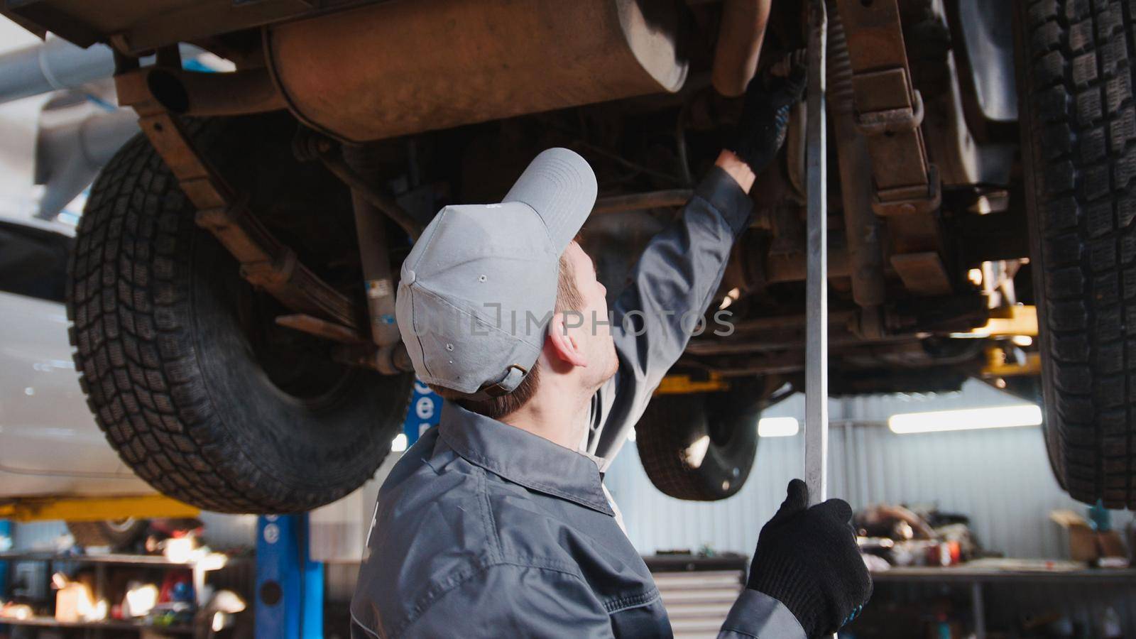 Mechanic checks the suspension in garage automobile service, close up