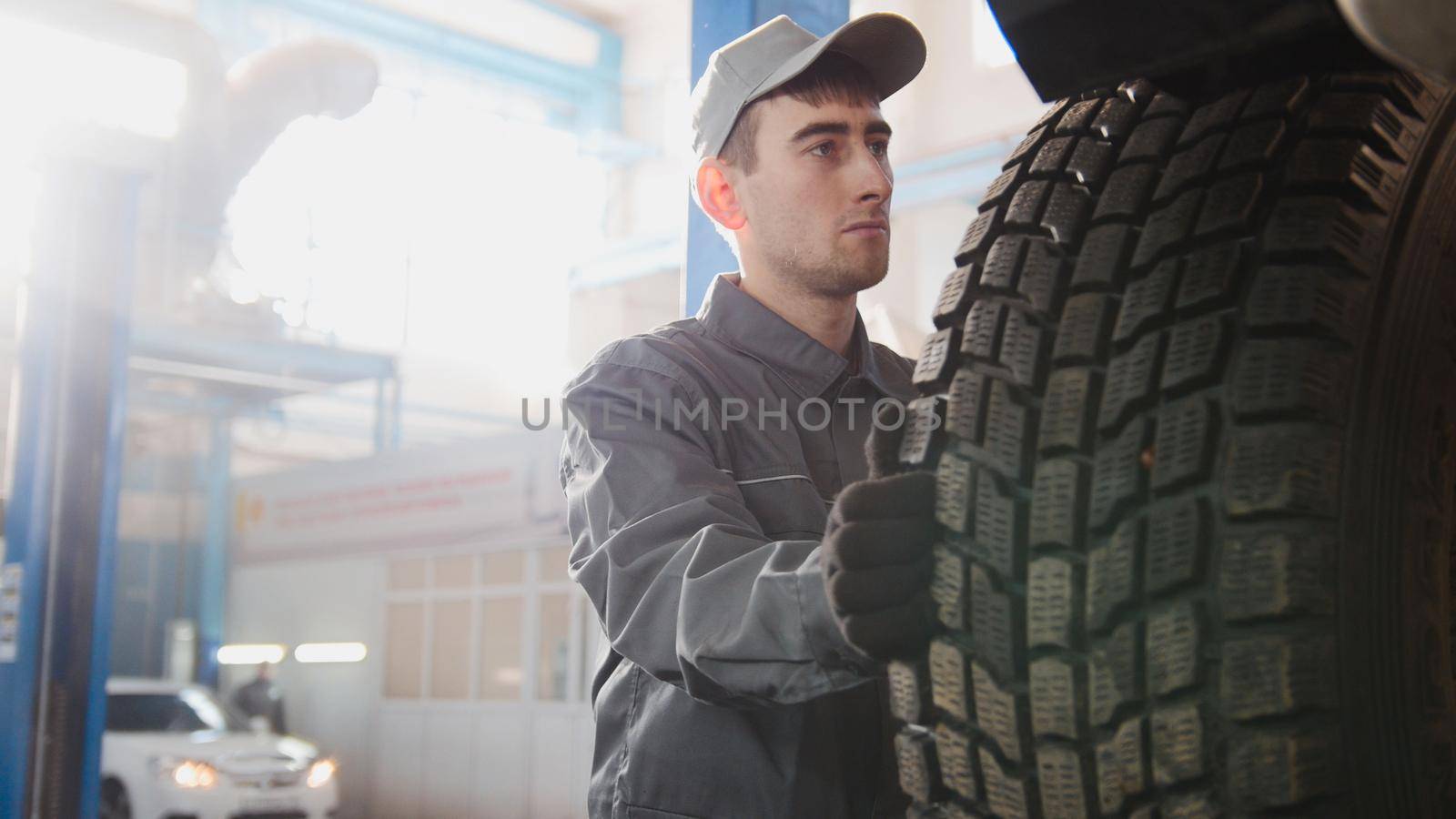 Car service - a mechanic checks the wheel of SUV, wide angle by Studia72
