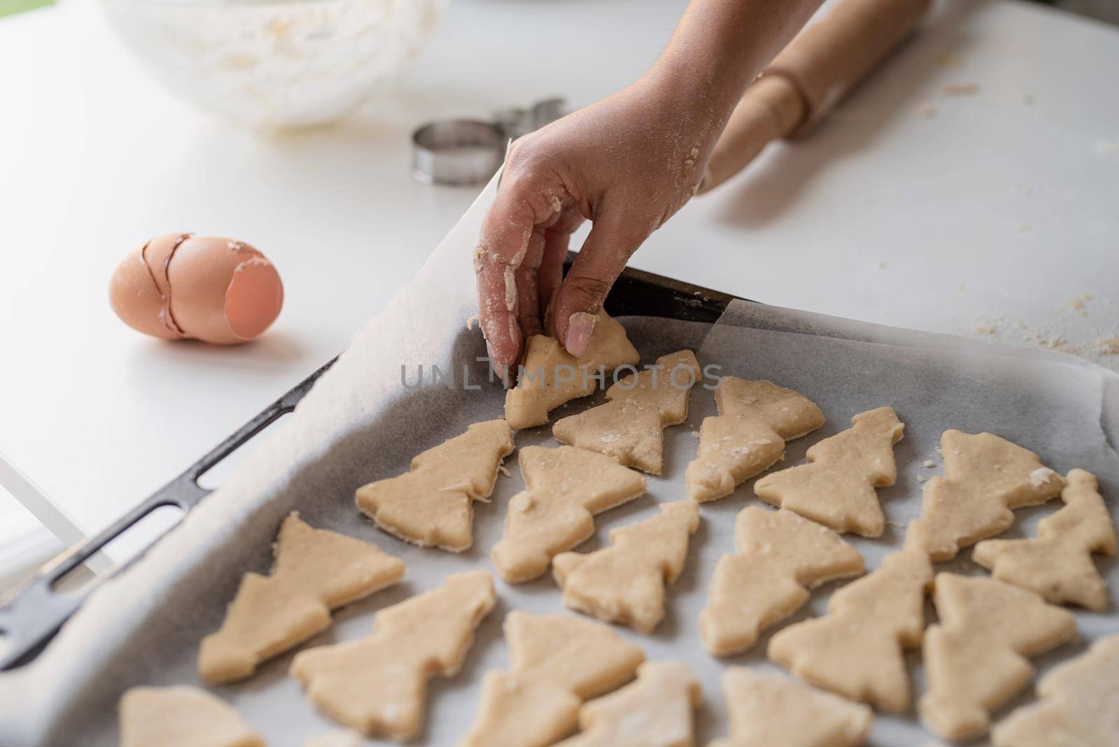 Smiling woman in the kitchen baking christmas cookies by Desperada