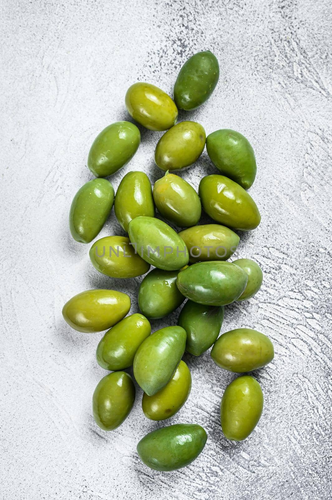 Fresh Green big olives on a table. White background. Top view by Composter