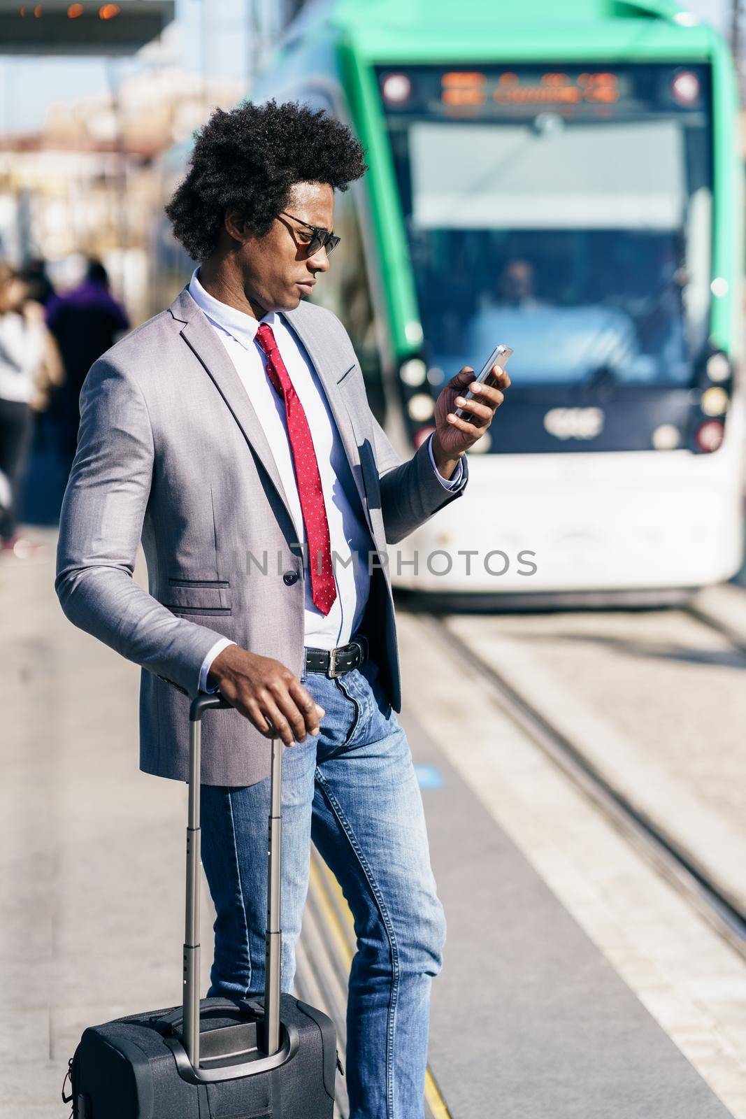 Black Businessman waiting for the next train. Man with afro hair commuting.