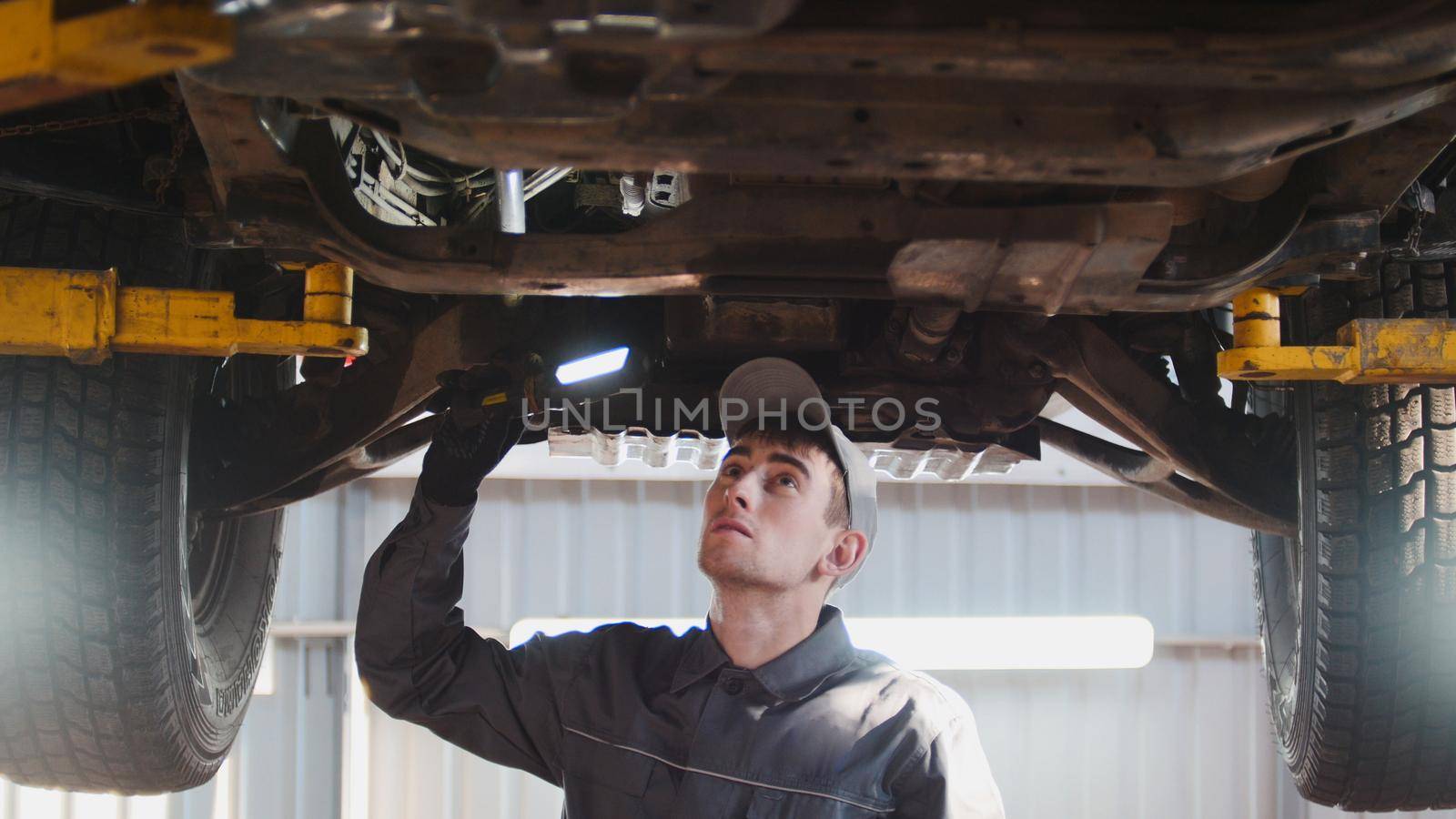Car service - a mechanic checks the suspension of SUV by Studia72