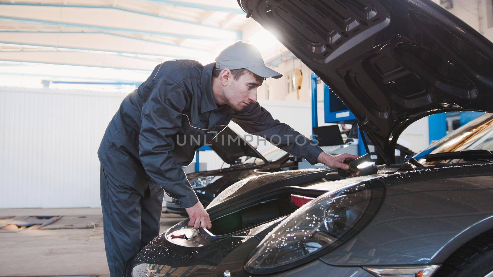 Hood for the sportcar - mechanic in automobile garage, telephoto