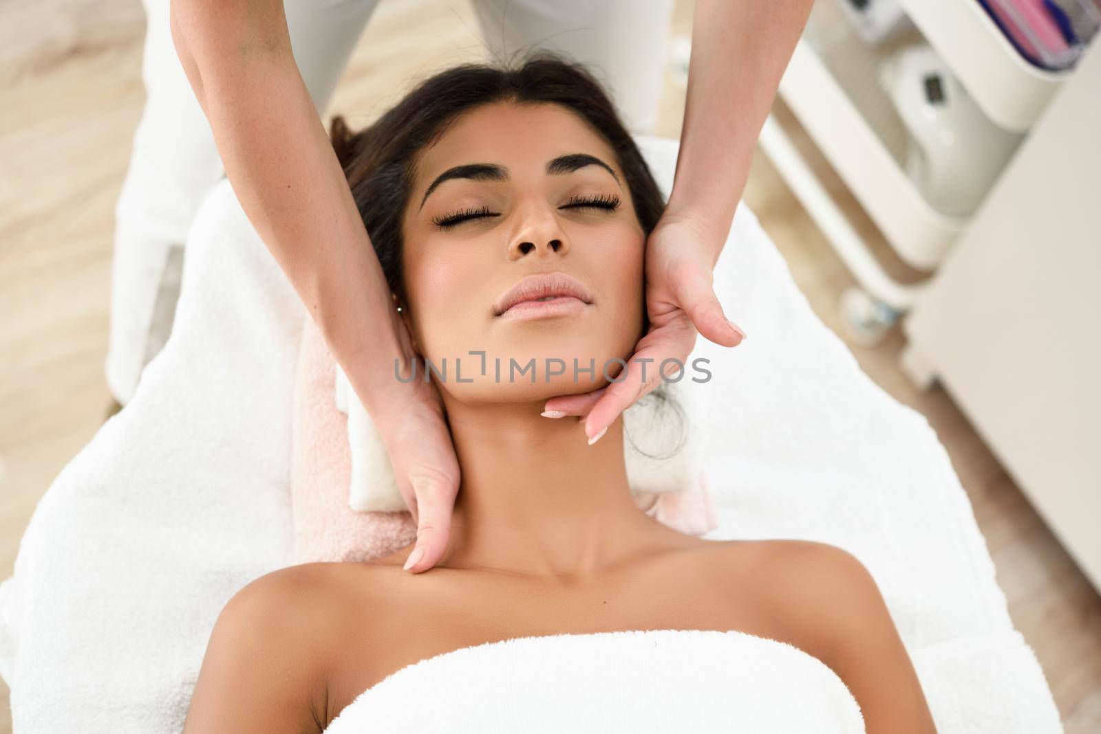 Woman receiving head massage in spa wellness center. by javiindy