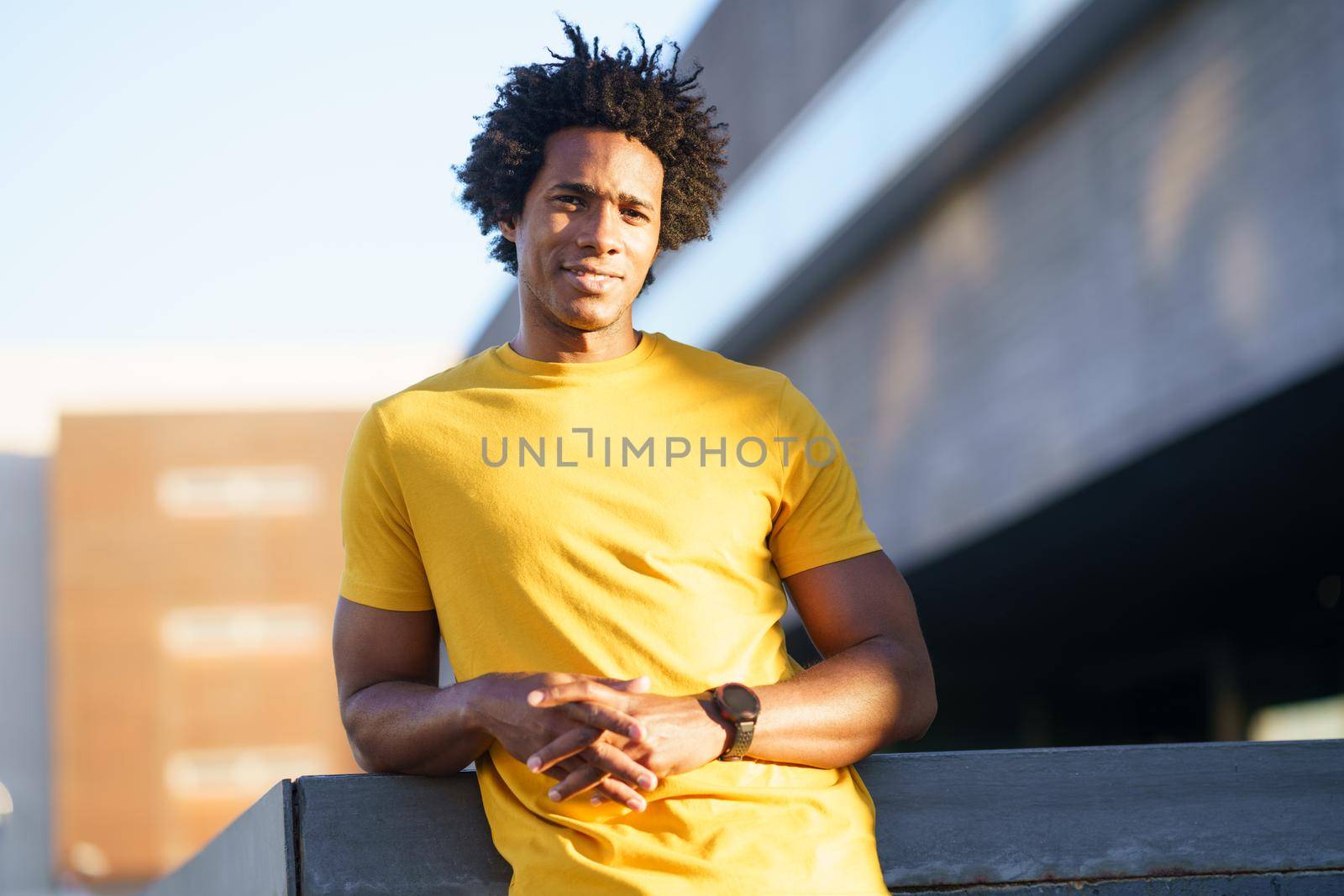 Black man with afro hair taking a break after workout. by javiindy