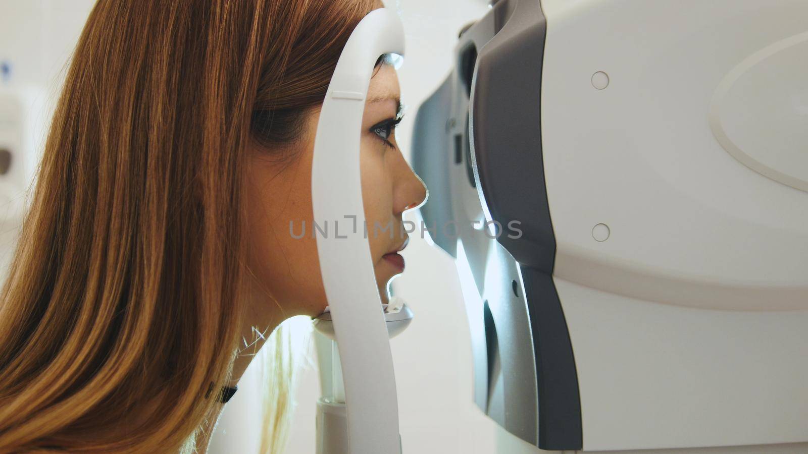 Female checks the eyes on the modern equipment in the medical center, close up