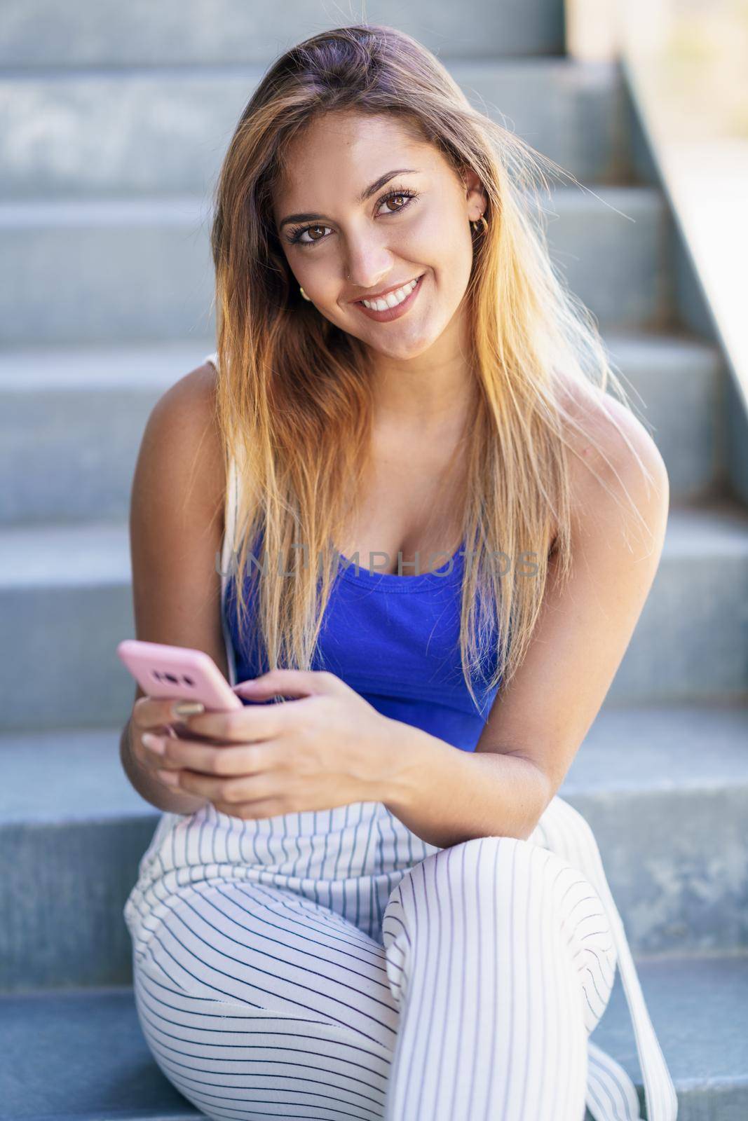 Girl using a touchscreen smartphone wearing casual clothes by javiindy