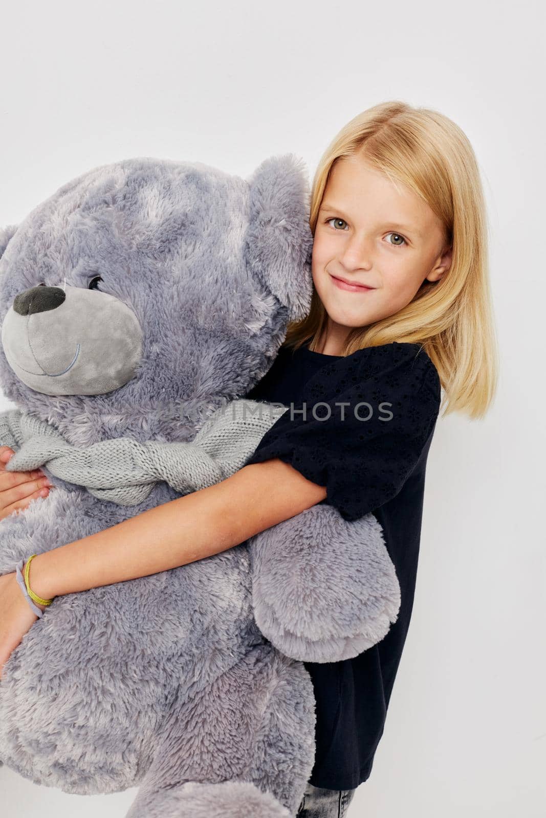 Beautiful little girl in a black t-shirt grimace isolated background. High quality photo