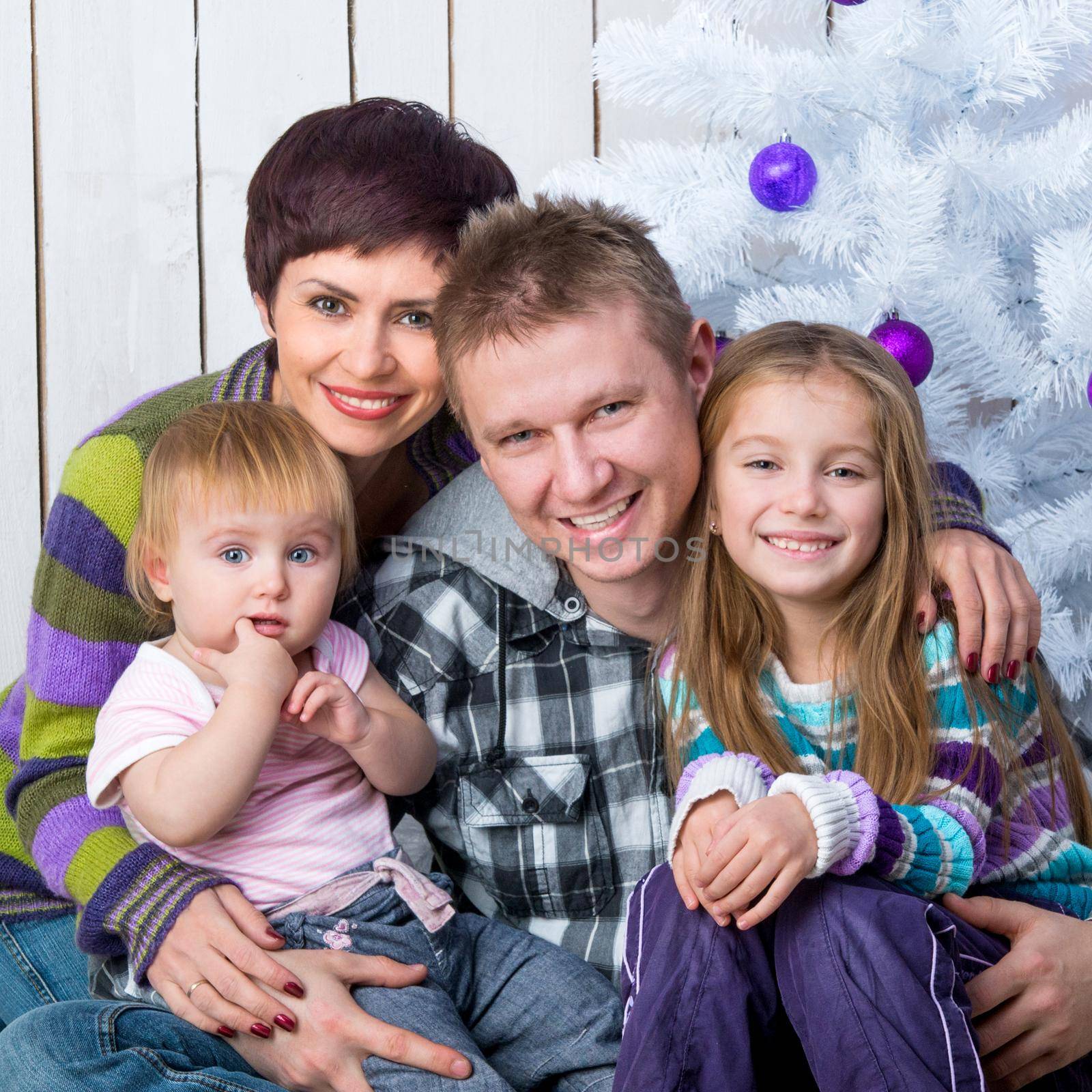 Christmas photo of a happy family around a decorated Christmas tree