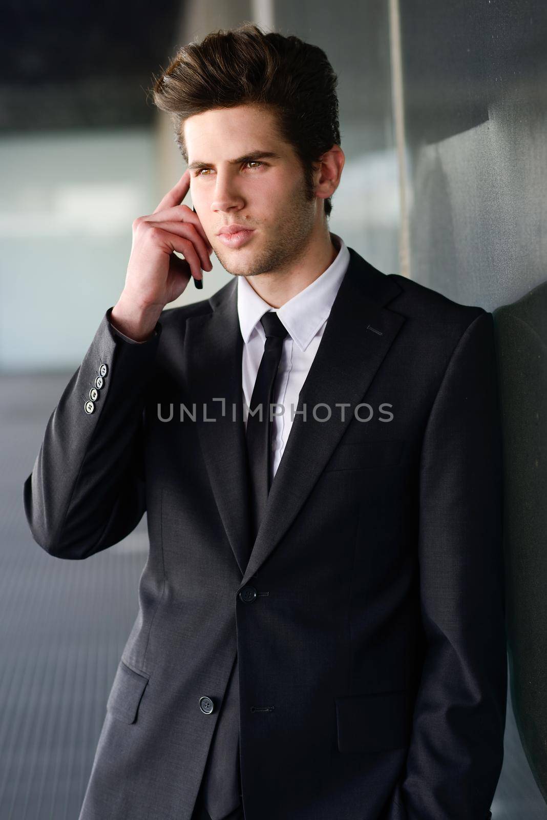 Attractive young businessman on the phone in an office building by javiindy