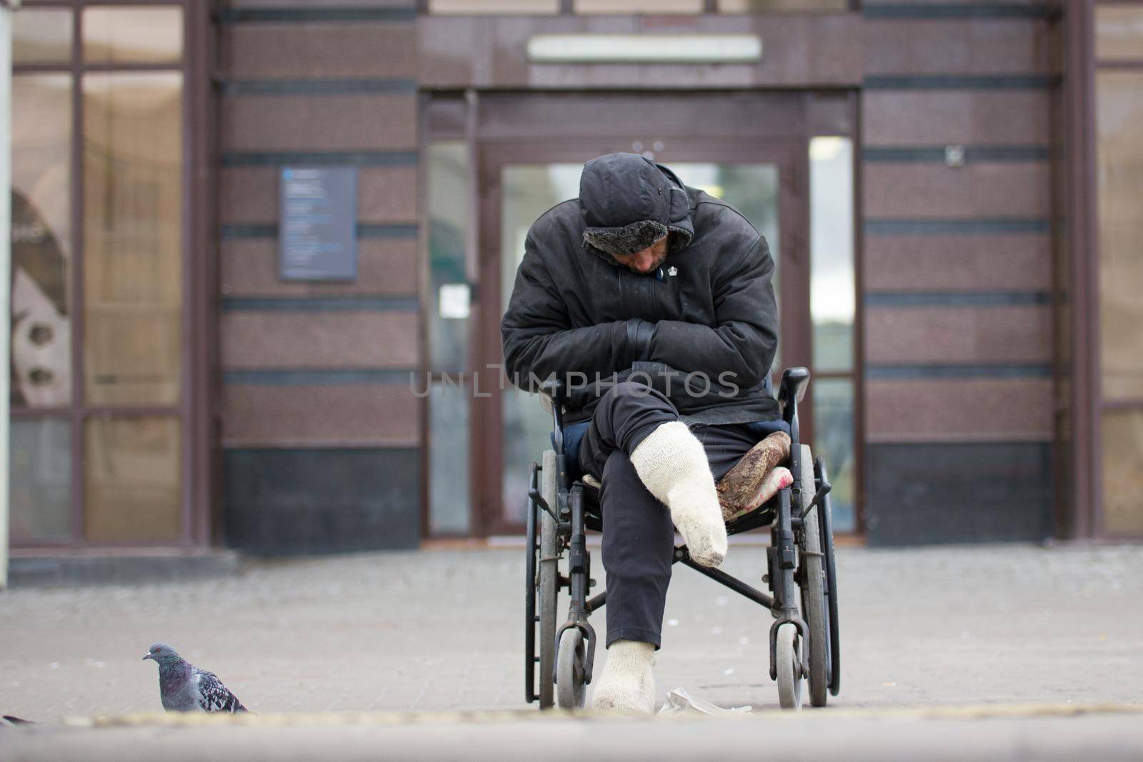 Russia, Kazan 14 september 2016, dowmtown - Disabled homeless man on a wheelchair begging for money - drunk beggar sleeping, telephoto