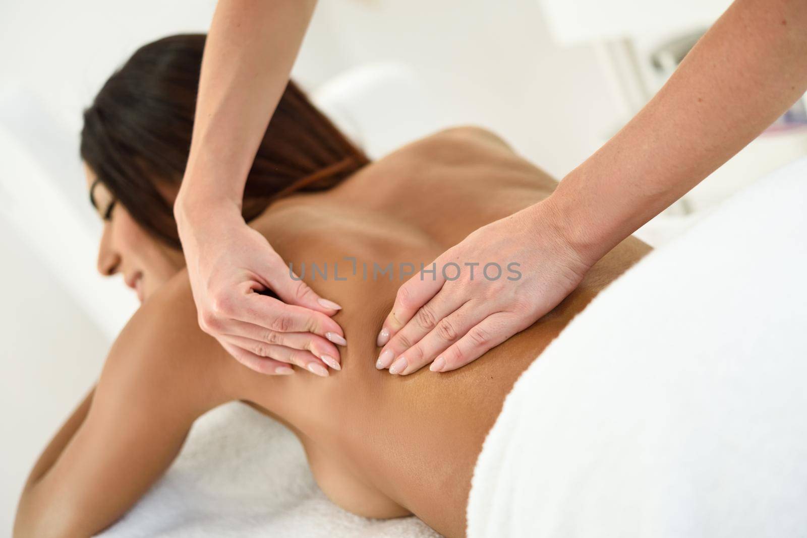 Arab woman receiving back massage in spa wellness center. Beauty and Aesthetic concepts.