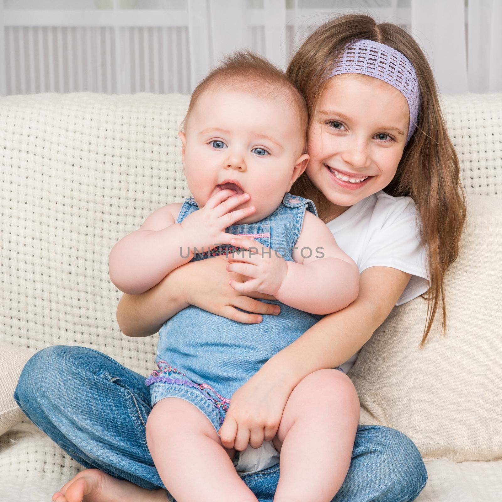 cute happy girl and her little sister at home