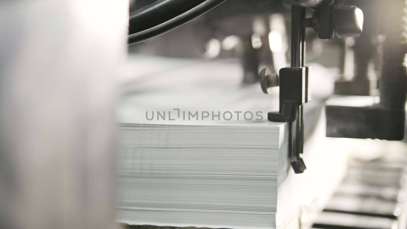 Printed sheets of paper are served in the printing press. Offset printing, CMYK, extremely close up