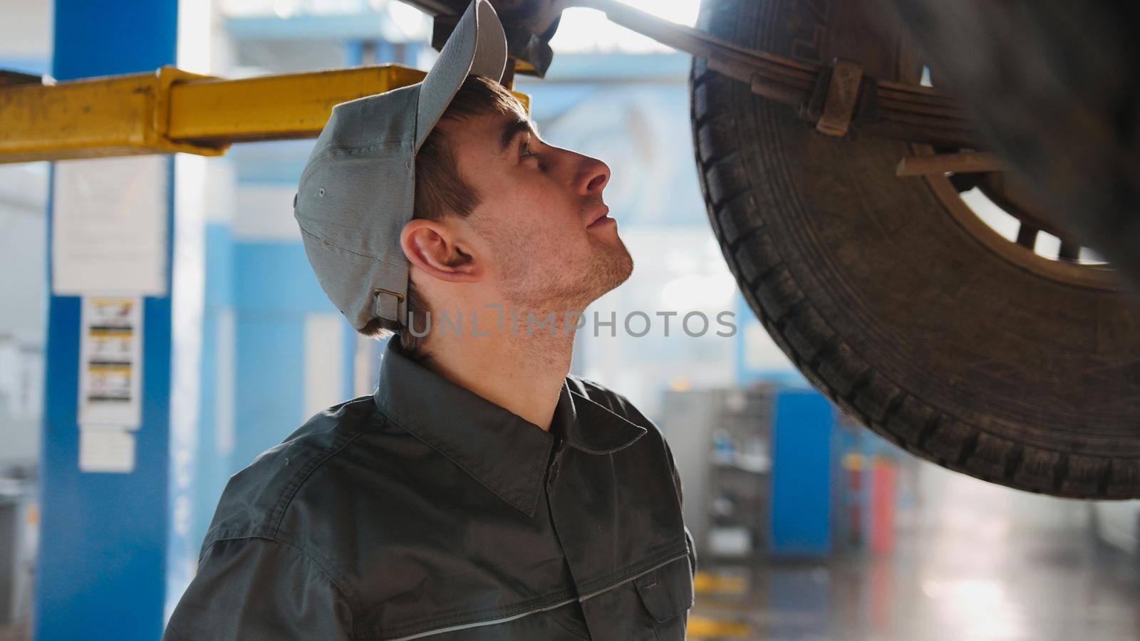 Mechanic is checking the wheel in garage automobile service, close up, telephoto