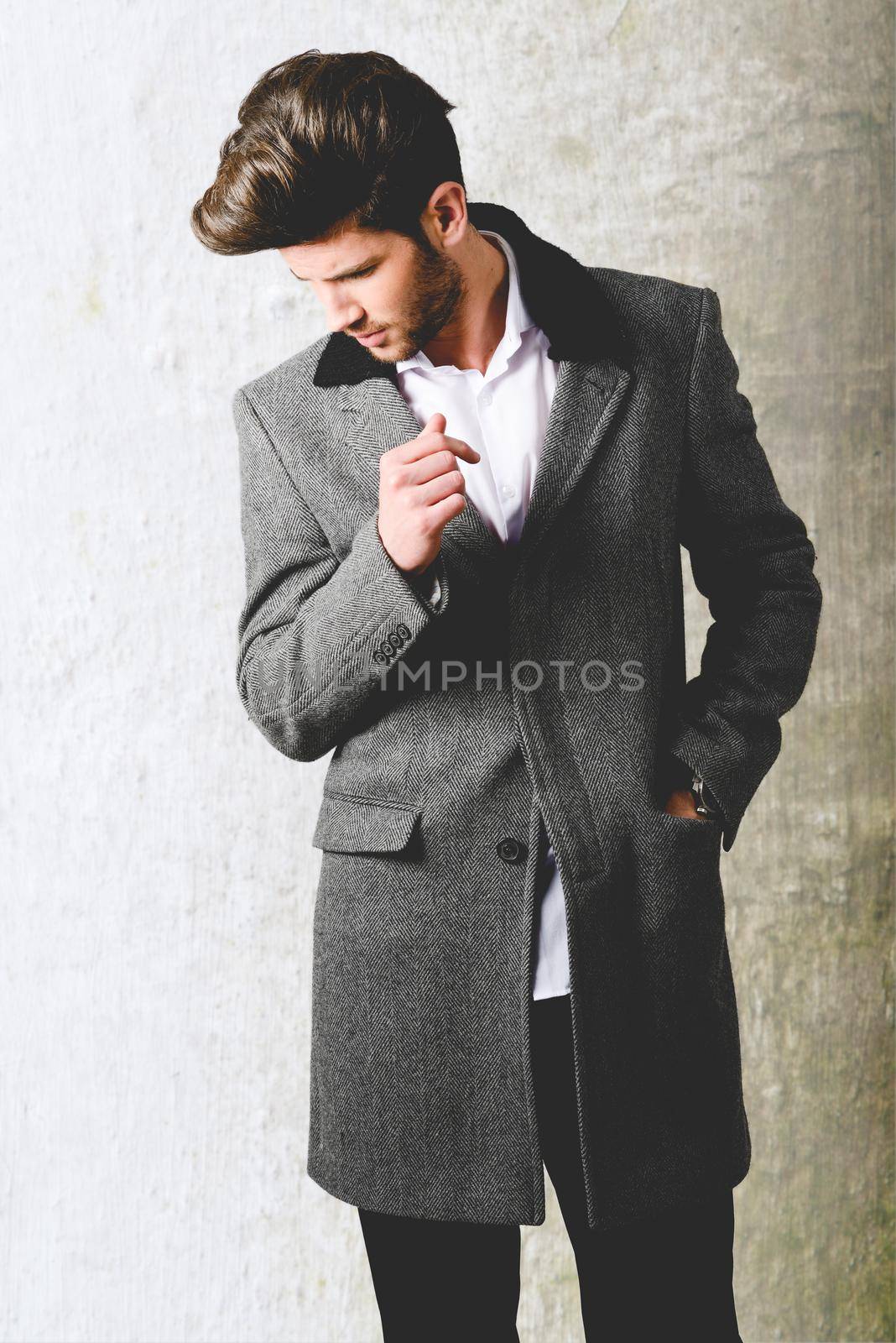 Handsome young man wearing coat. Studio shot by javiindy