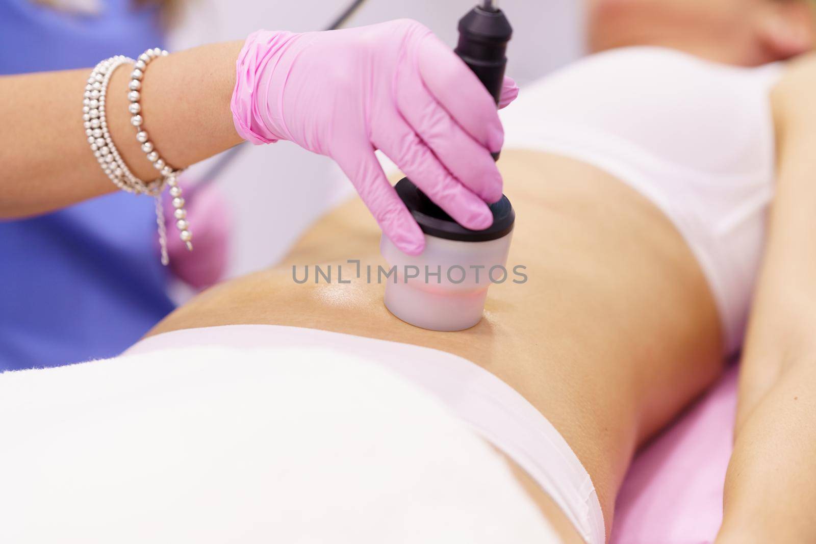 Woman receiving anti-cellulite treatment with radiofrequency machine in a beauty center. by javiindy