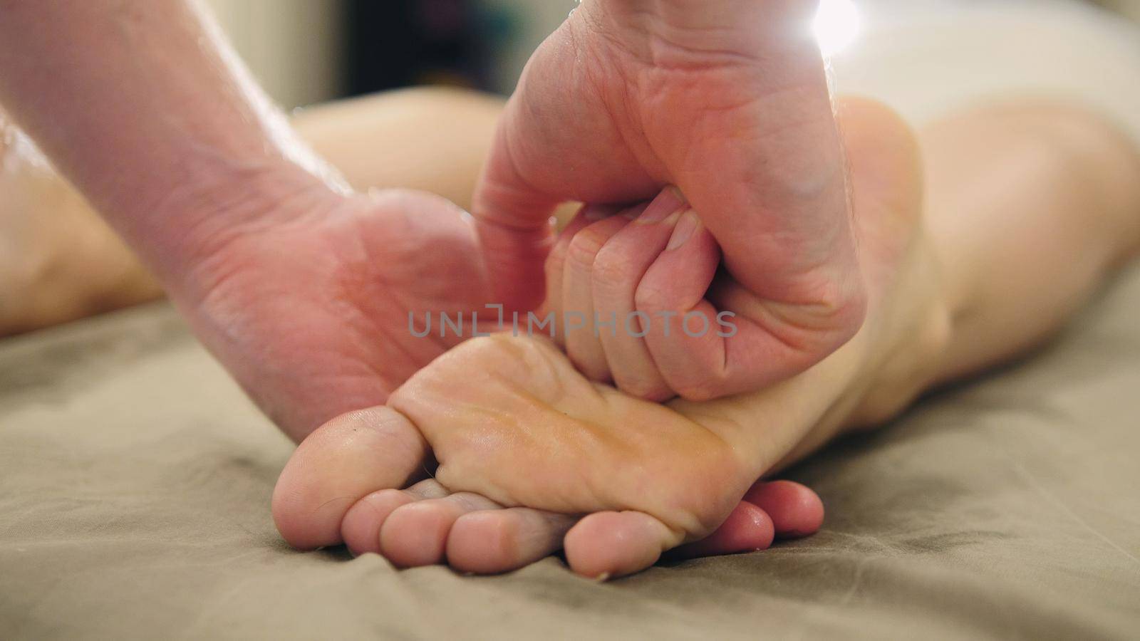 Foot massage in the spa salon - relaxation therapy, cosmetic and healthcare concept, close up
