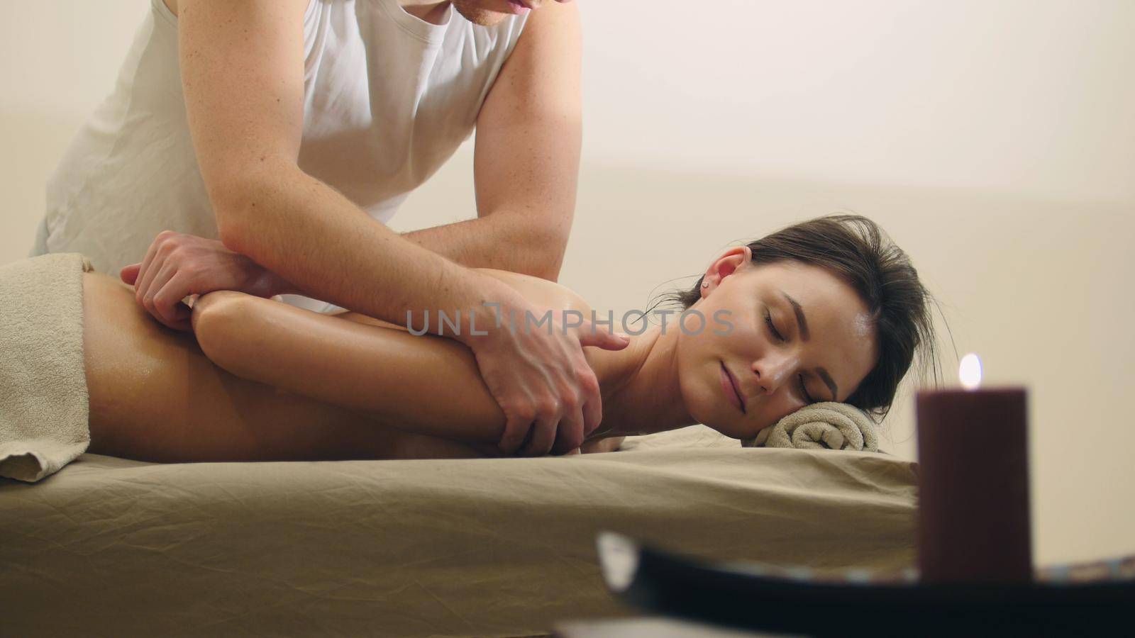 Classical massage in the spa salon - relaxation therapy for attractive young model, close up