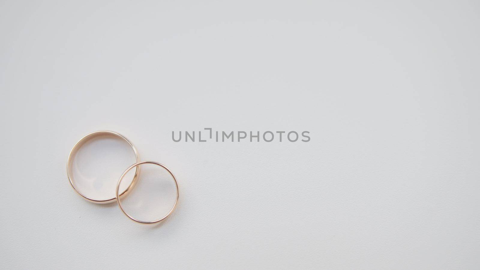 Golden wedding rings on white background, close up