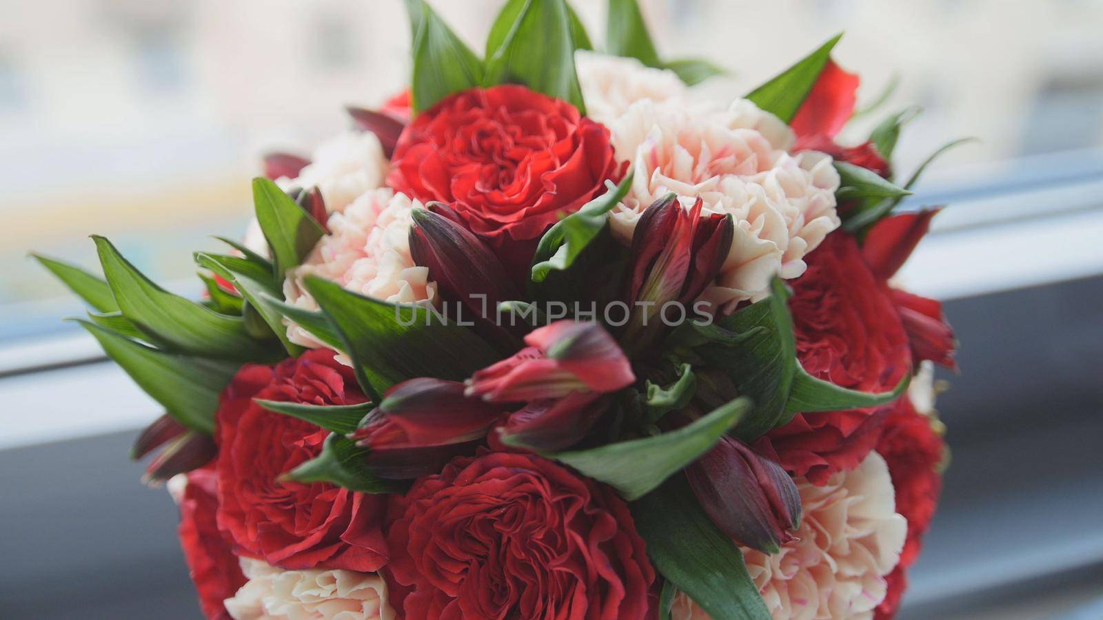 Colorful - red and green - wedding flowers - bride's bouquet at window, horizontal, close-up