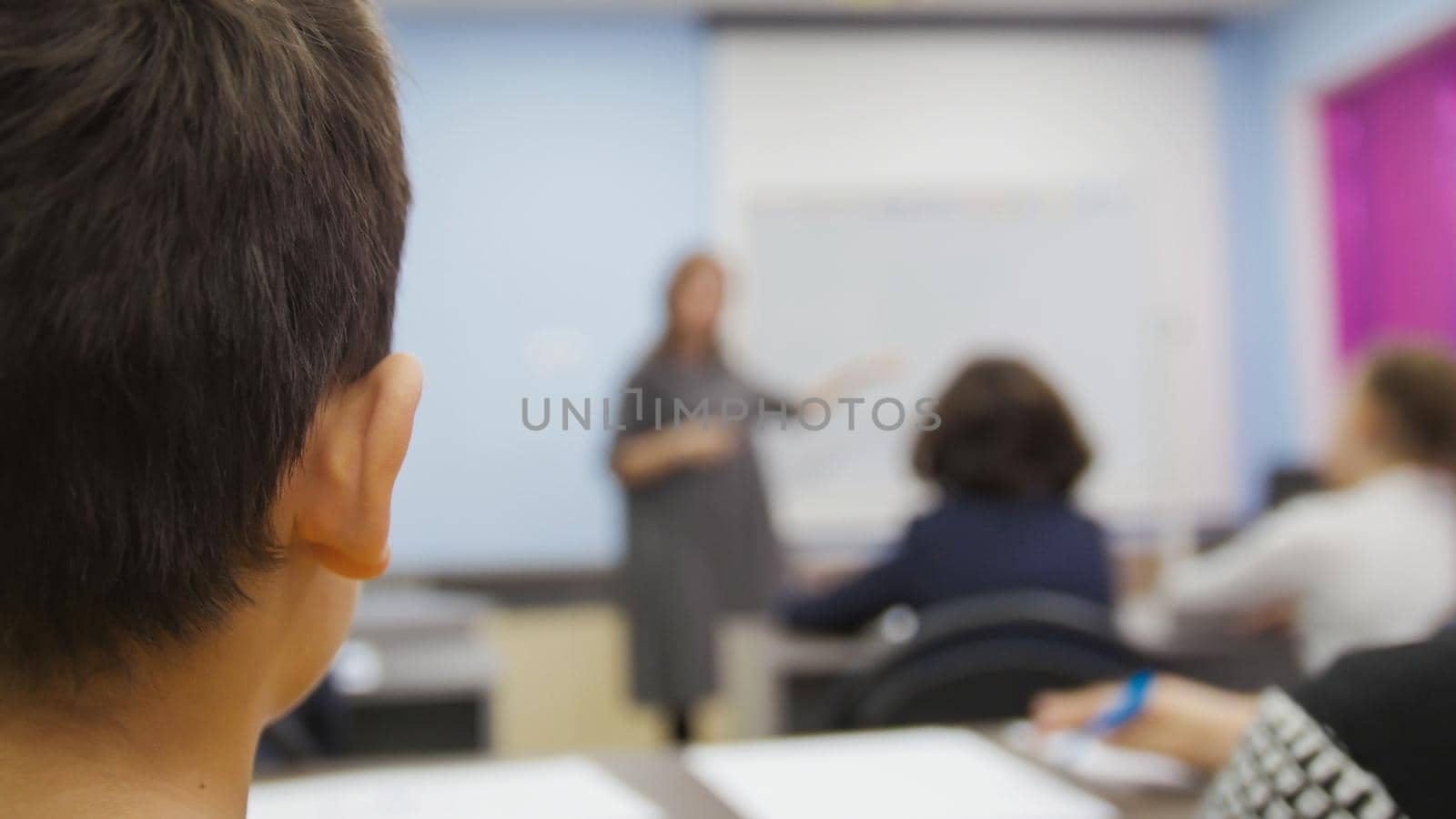 Classmates on school - children boy looking during the teacher explains the lesson, close-up telephoto shot