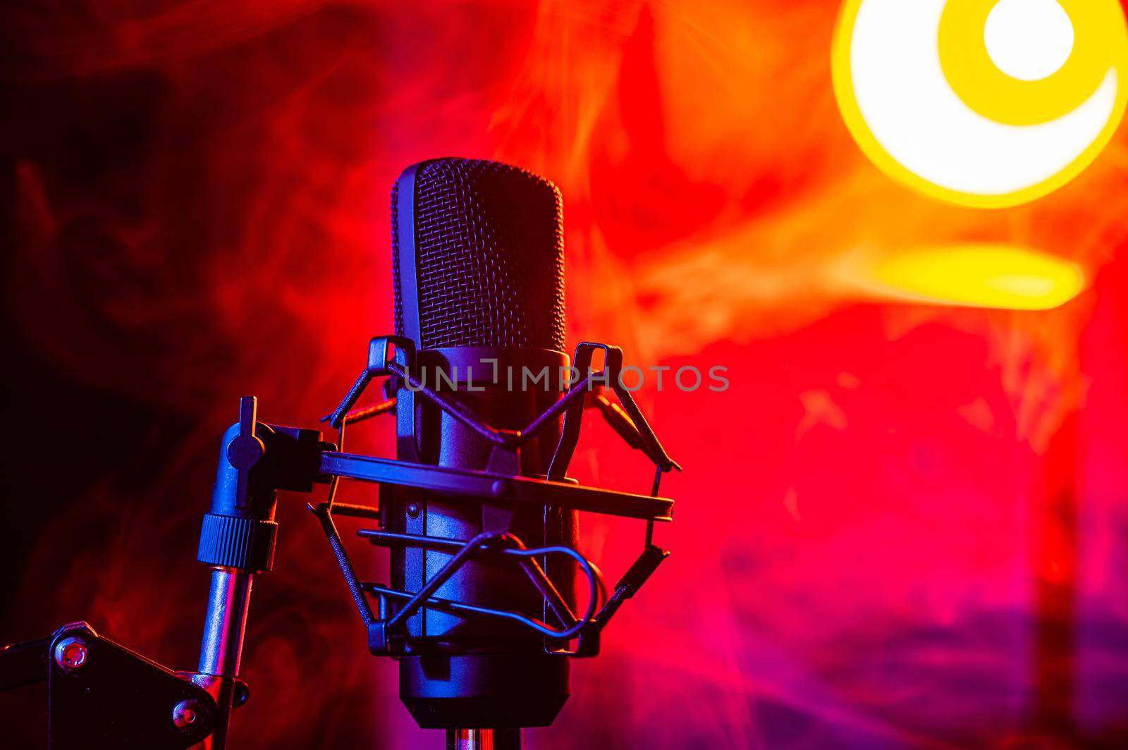 Professional microphone in red smoke on a black background